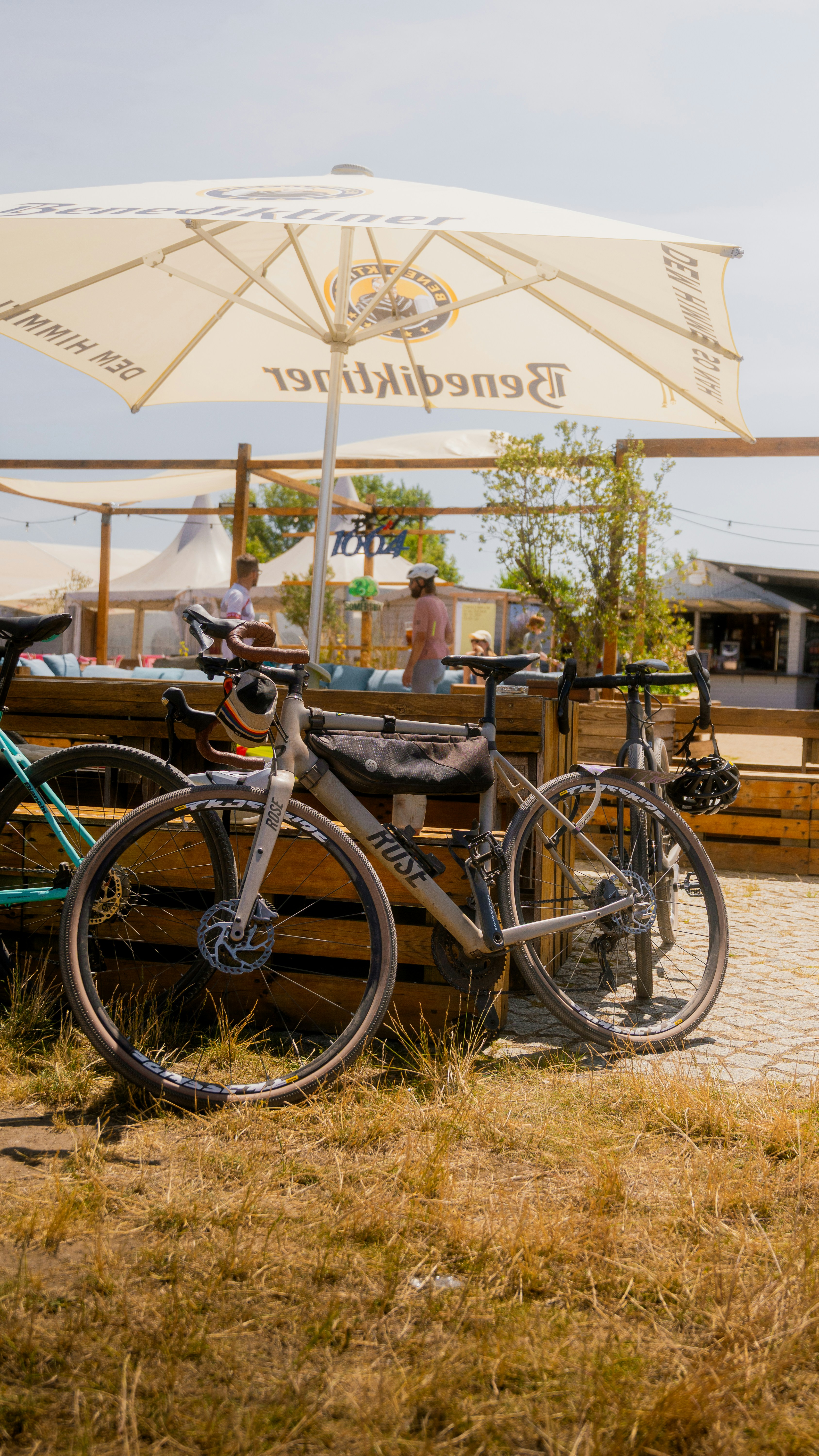 Bicycles sit near an outdoor cafe under an umbrella.