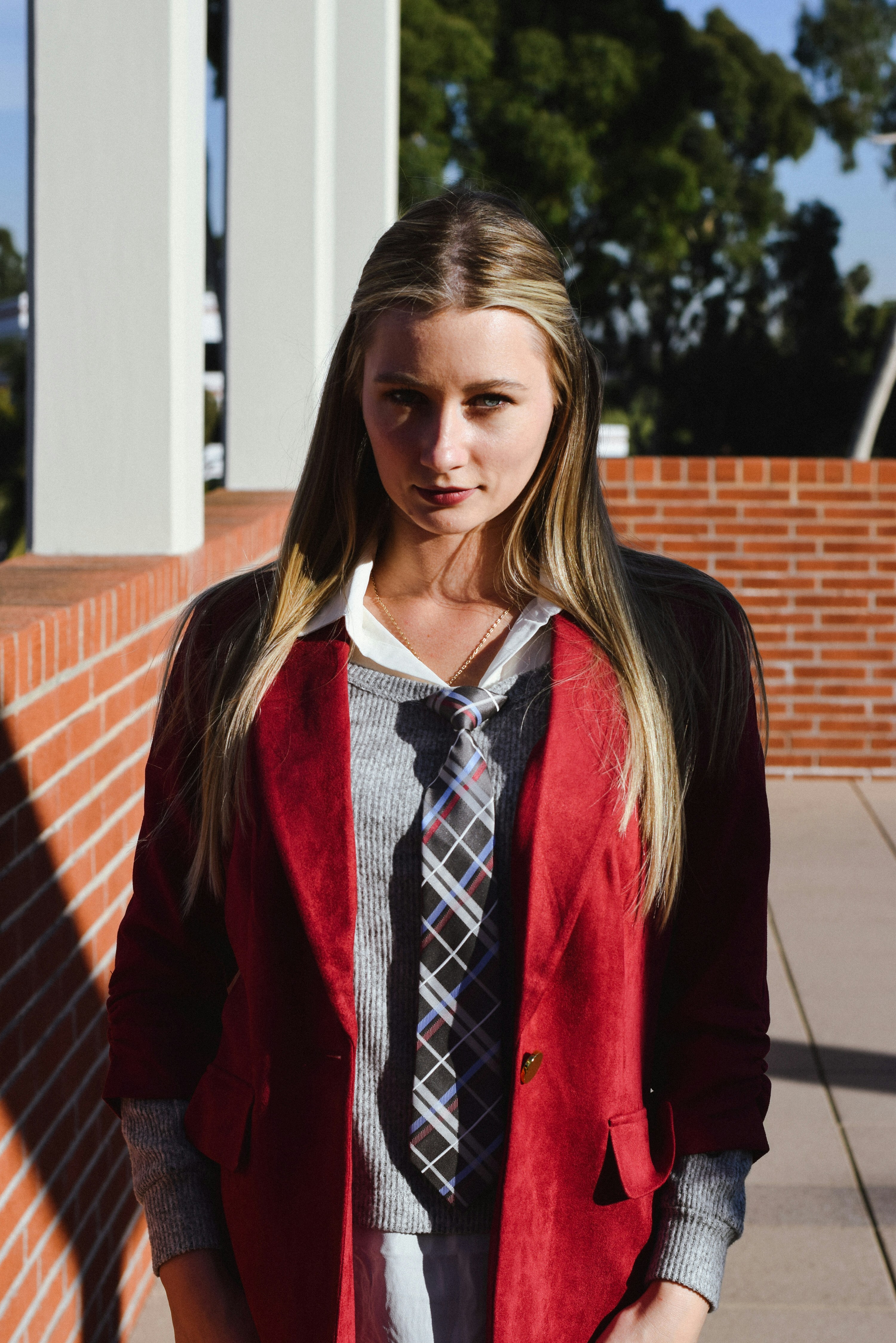 Una donna con un blazer rosso guarda attentamente.