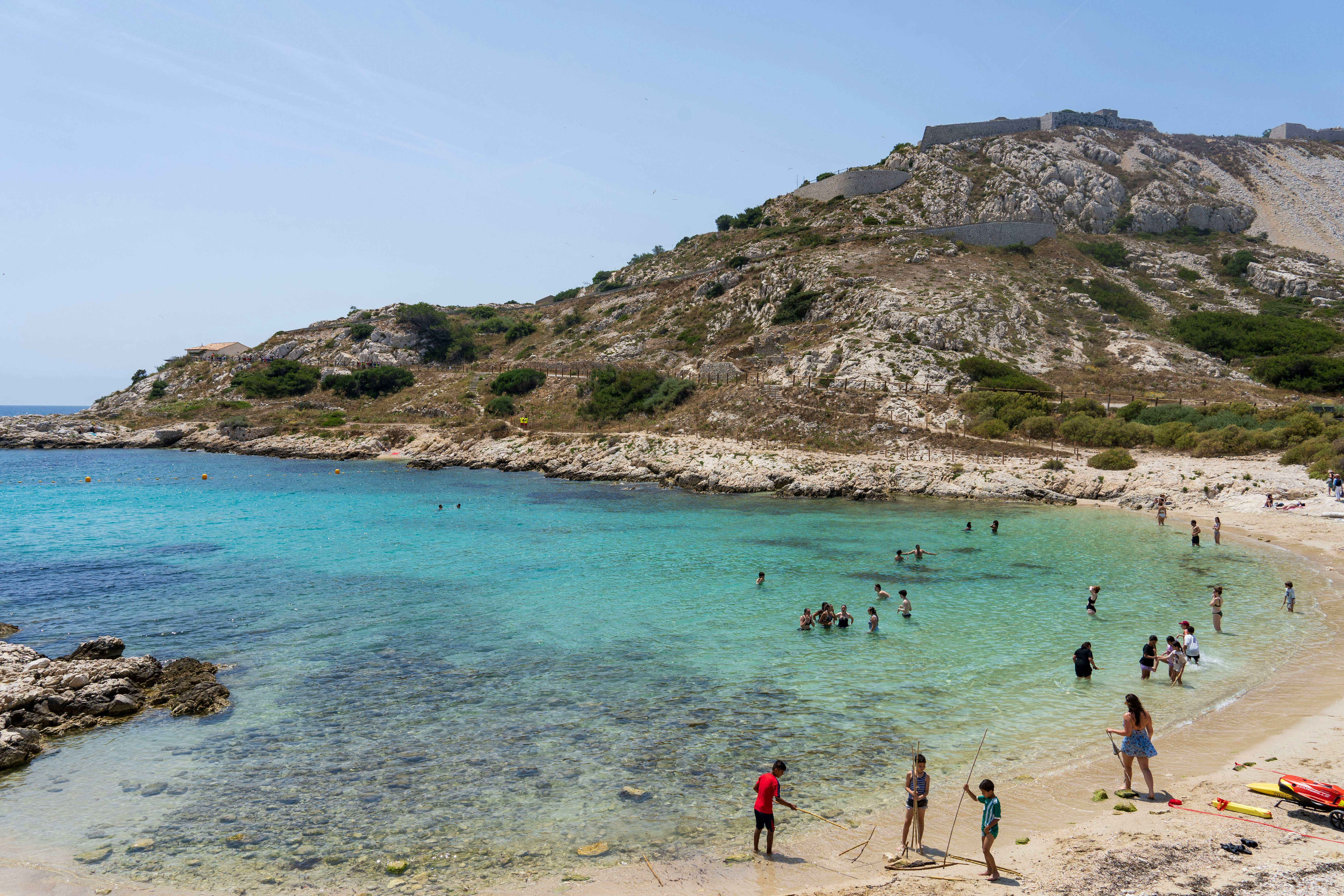 Die Menschen schwimmen gerne im kristallklaren Wasser.