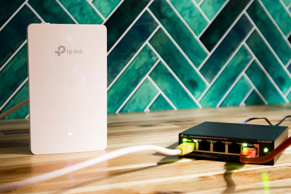 A Wi-Fi router and a network switch side by side, representing an IT hardware refresh