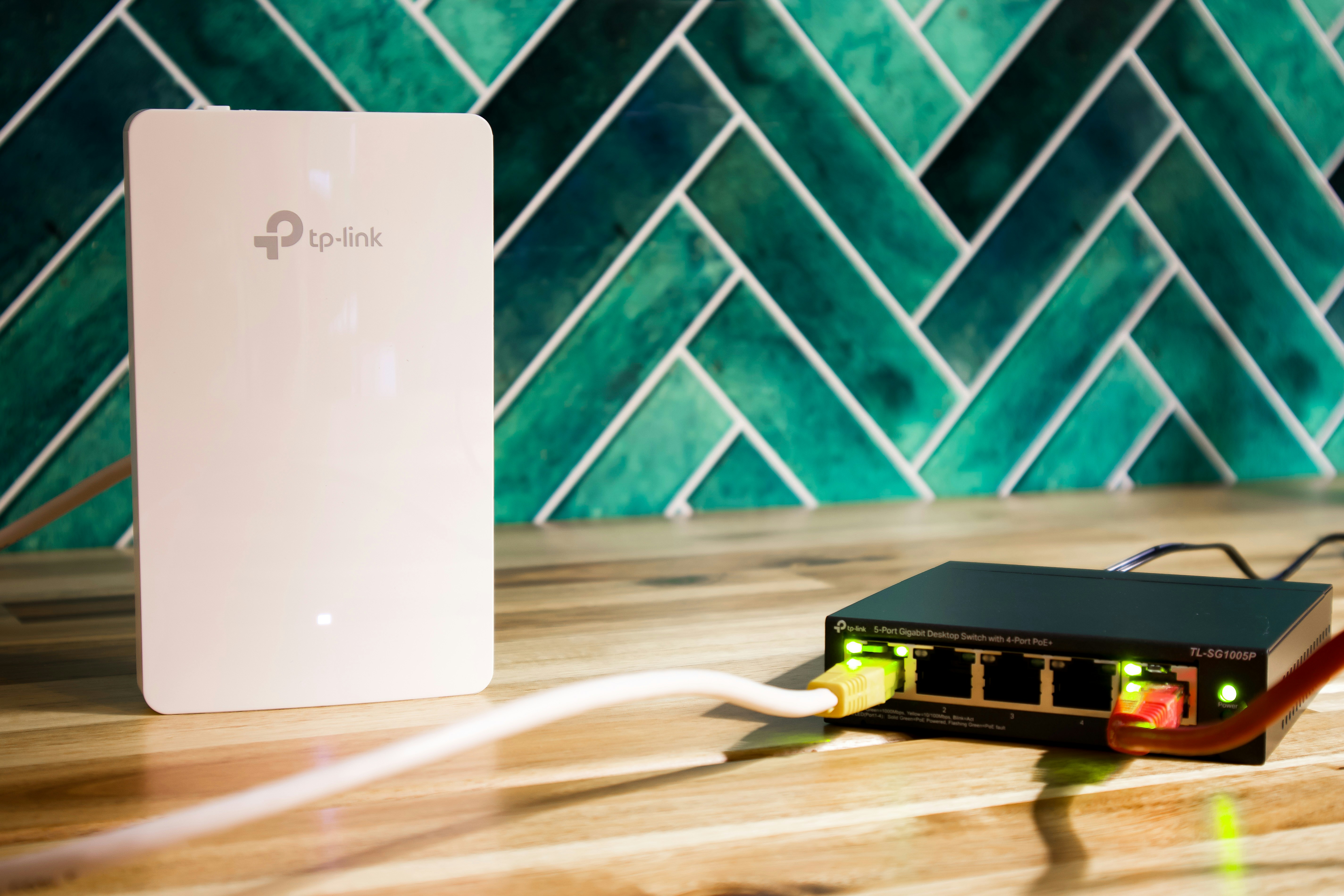 multi unit white wi-fi 7 mesh router system sitting on modern wooden shelf