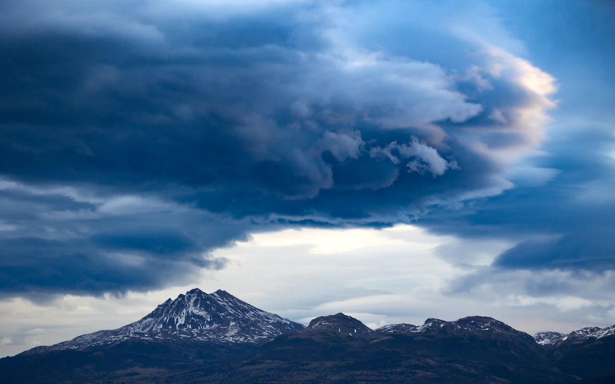 Snow-capped ridgeline under dramatic clouds