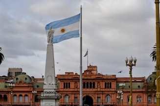 Argentinian flag waving near a prominent building.