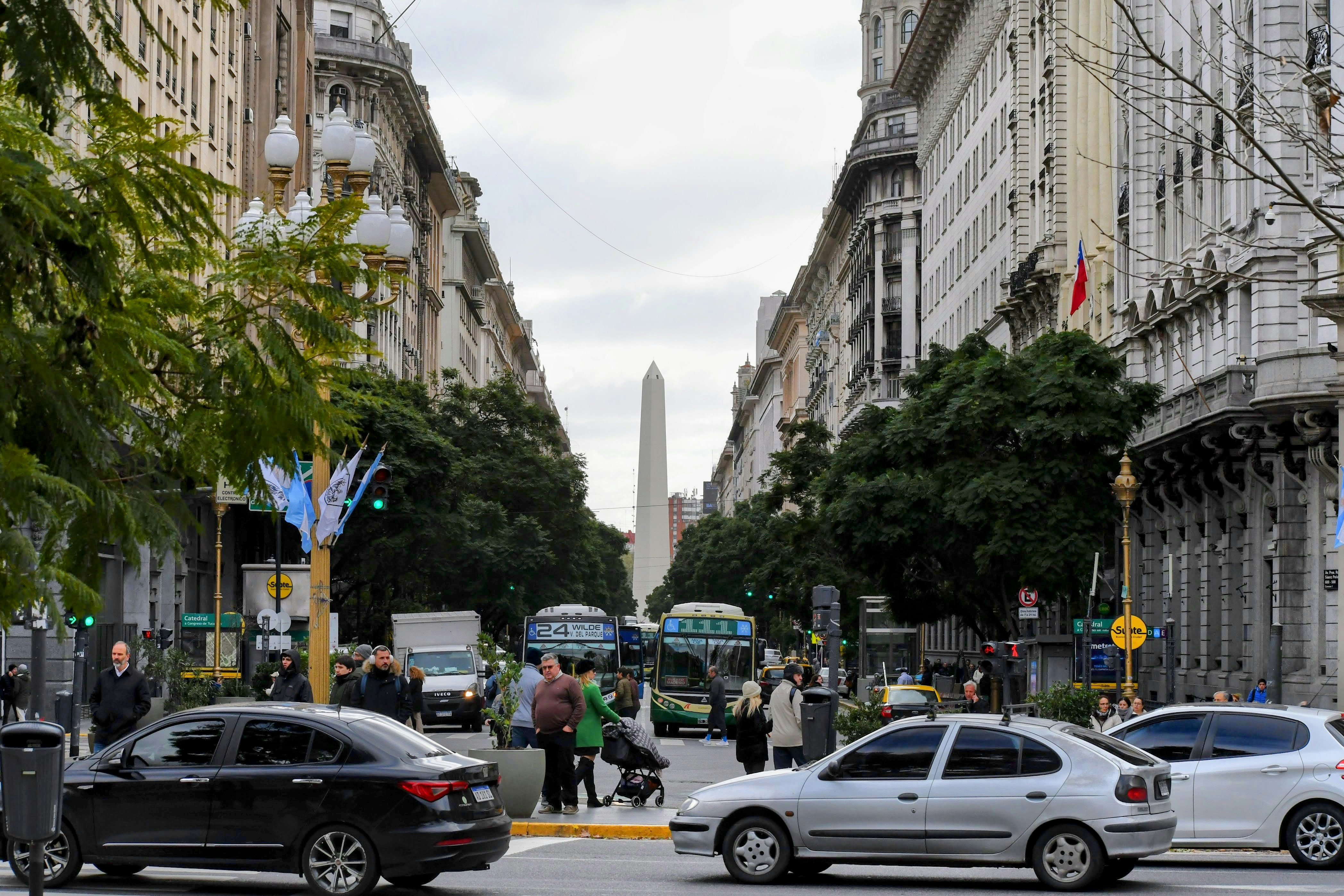 A street leads to an obelisk in buenos aires.