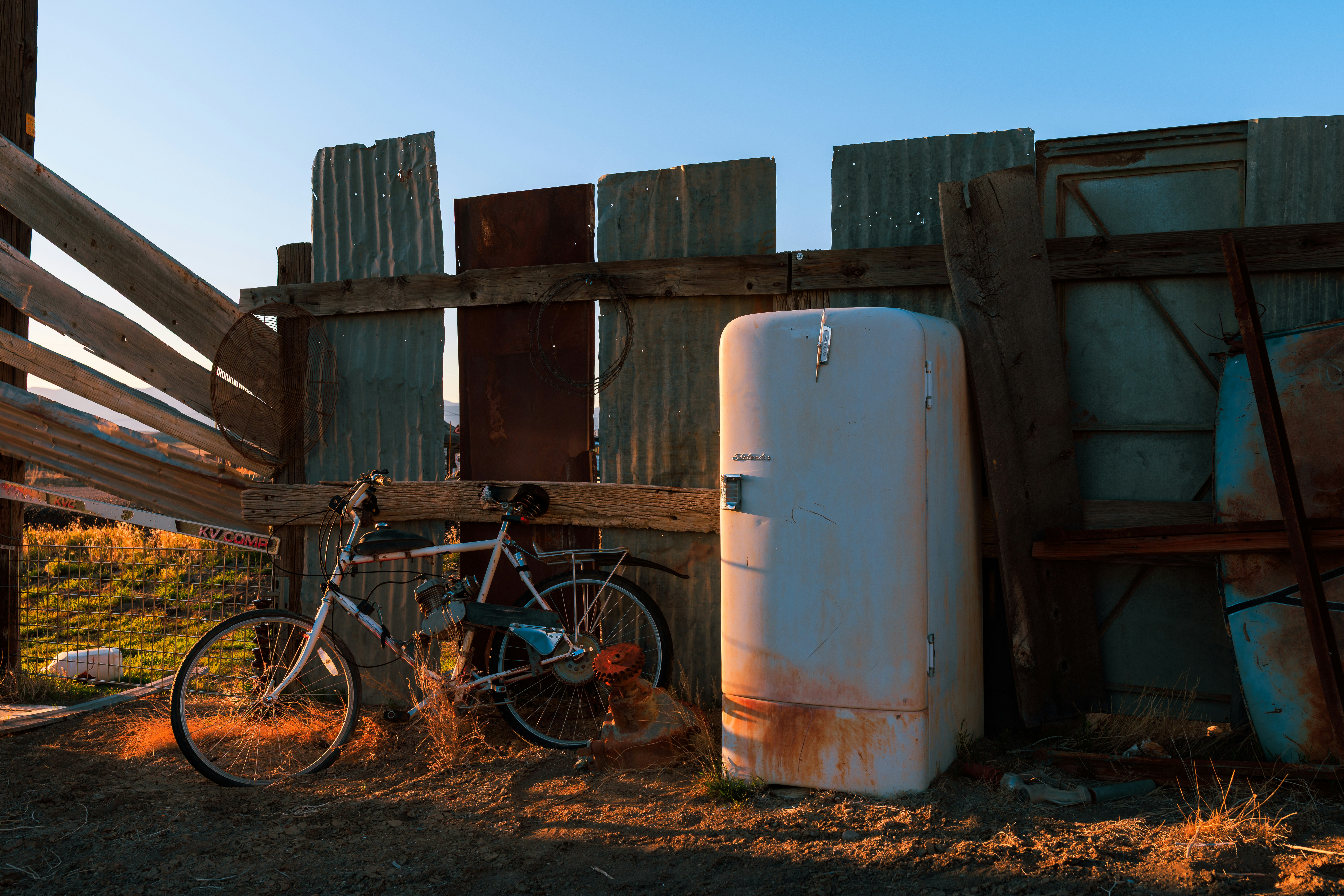 A bicycle and other items rest in a weathered enclosure.