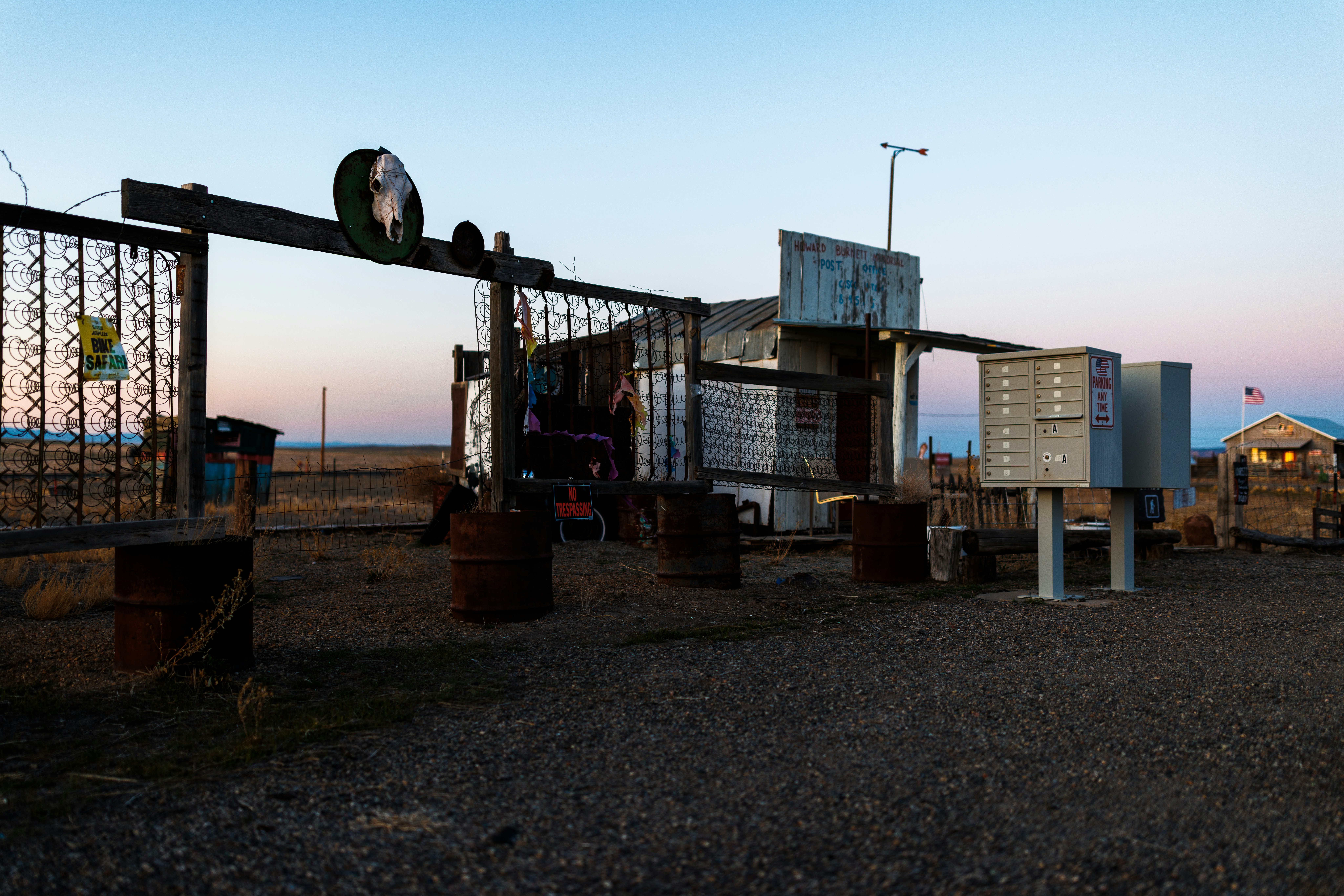 An abandoned, rustic outdoor structure at dusk.