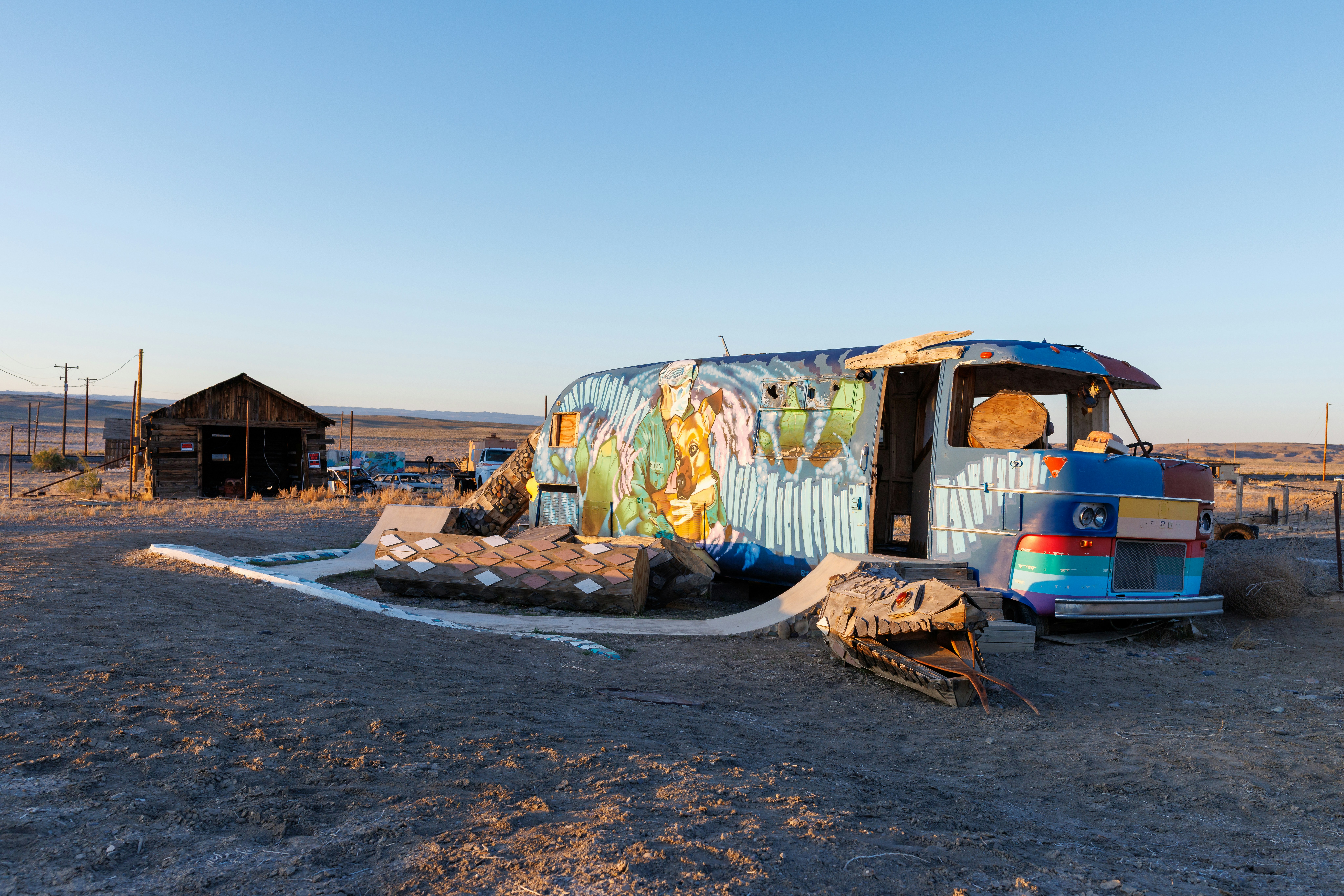 An old, colorful camper sits in the desert.