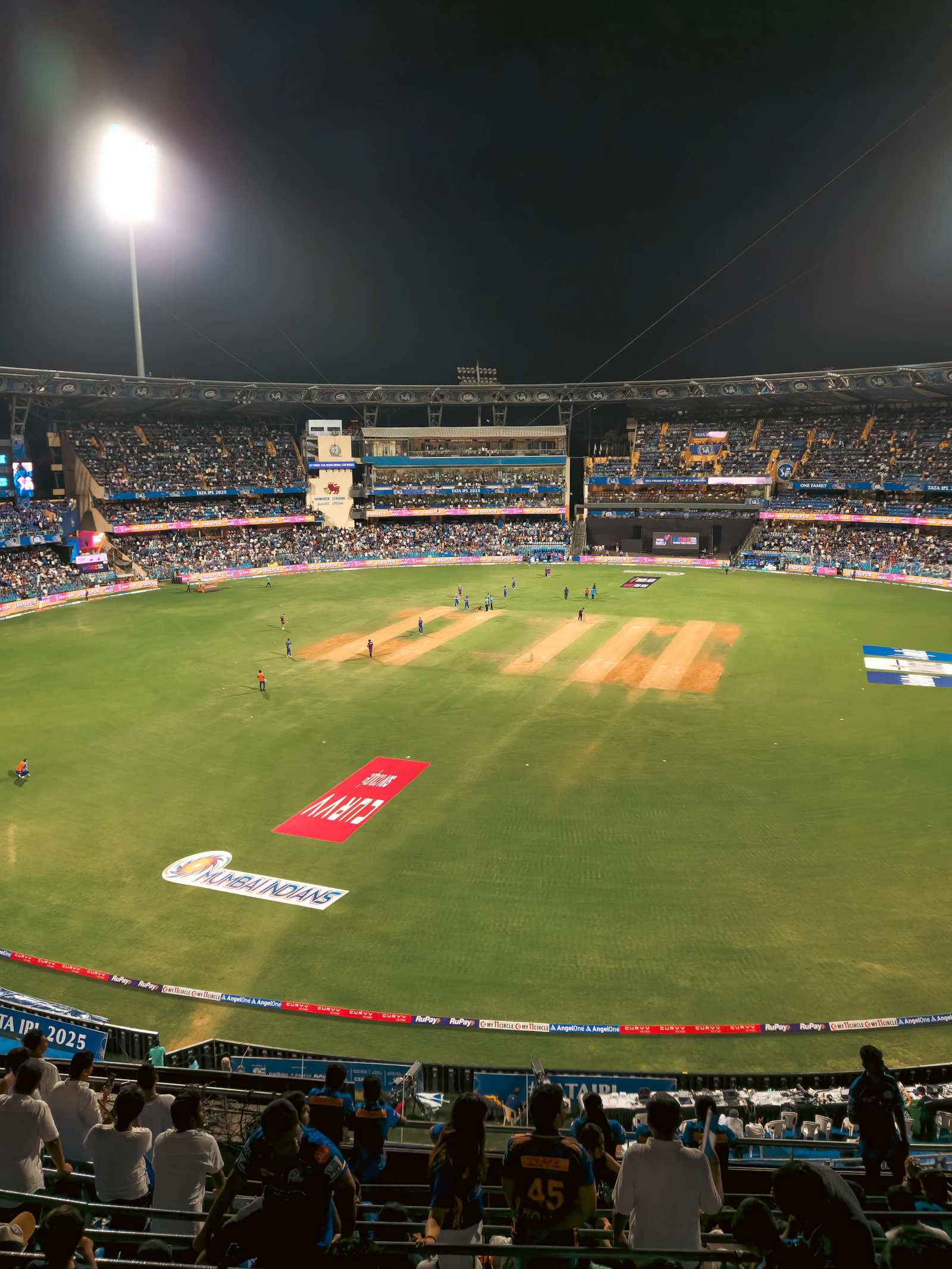 Night cricket match under floodlights