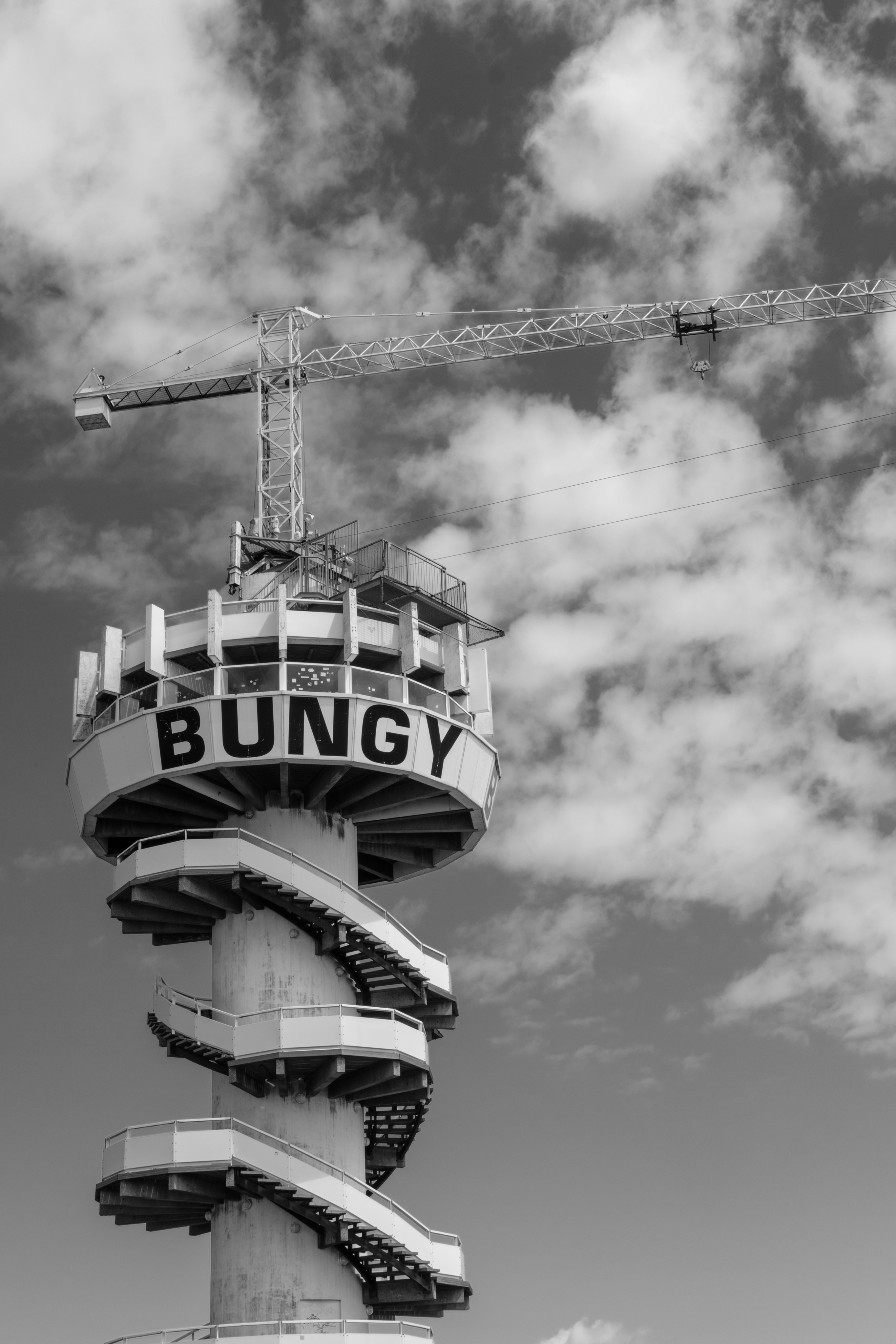 A bungy jump tower with a cloudy sky backdrop.