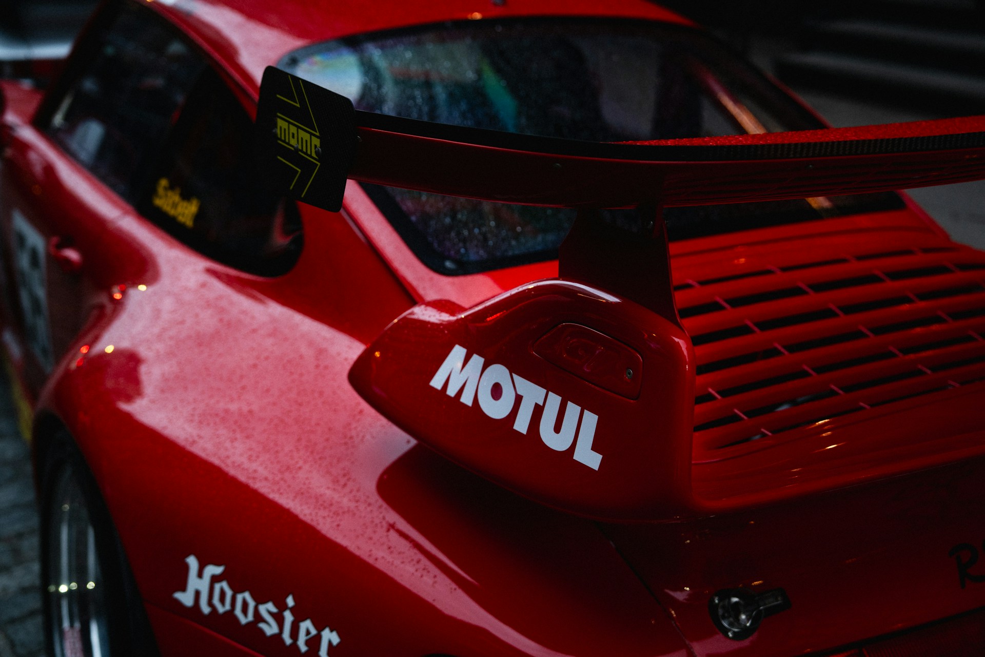 A red race car's spoiler is shown.