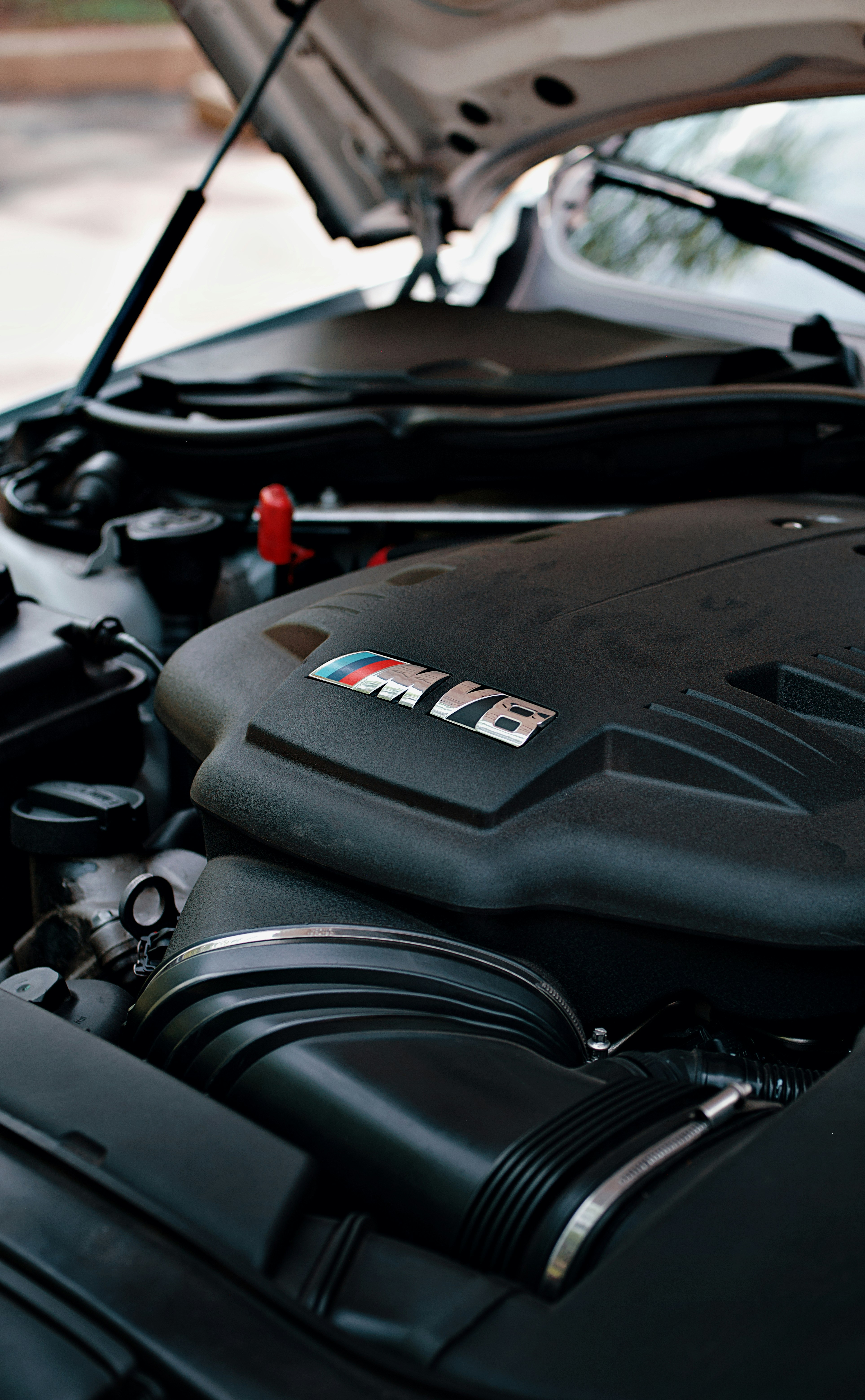 Viene mostrato un motore BMW con il cofano aperto.