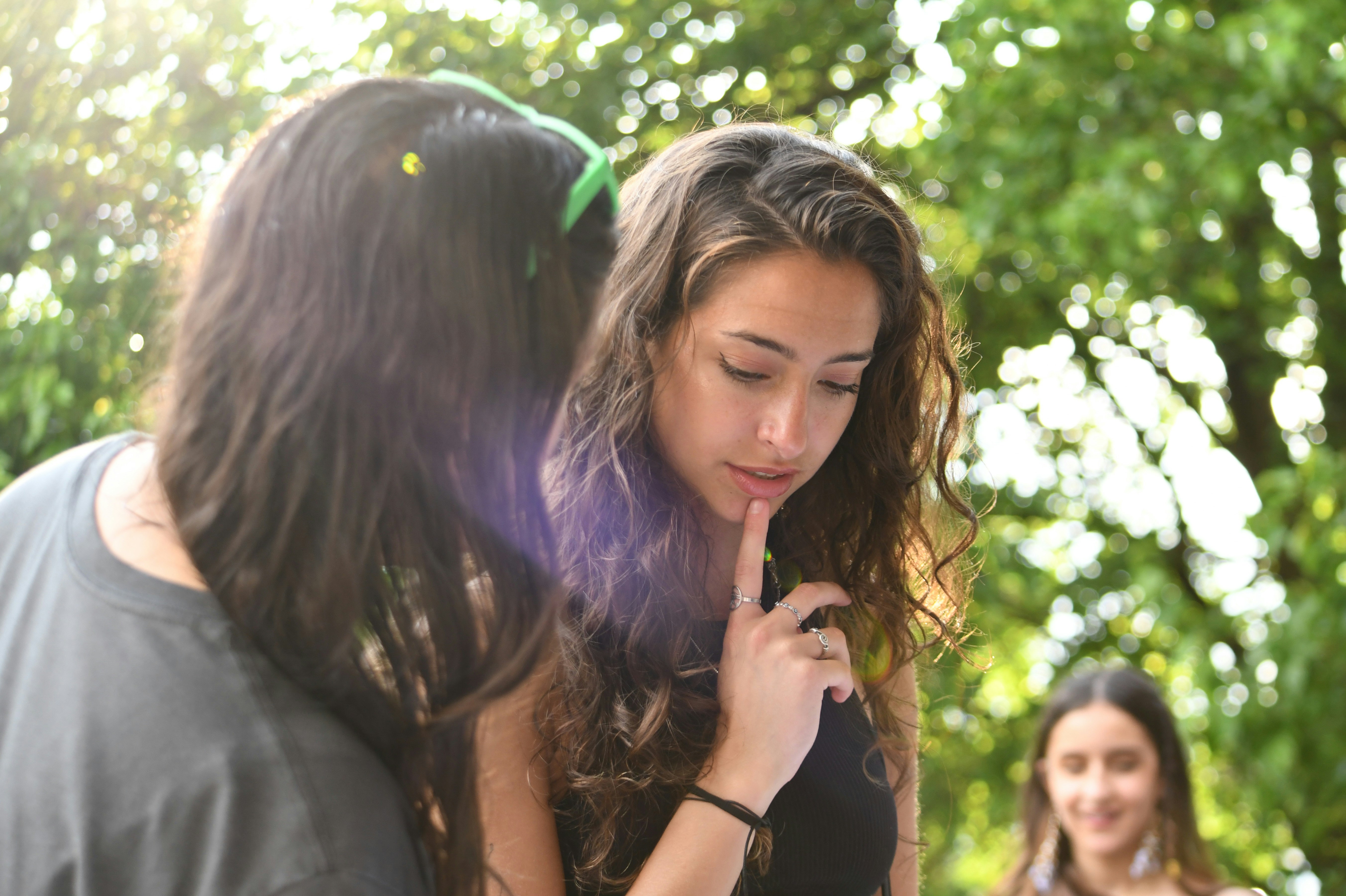 A woman is whispering to a friend.
