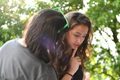 Two girls are looking down at something together.