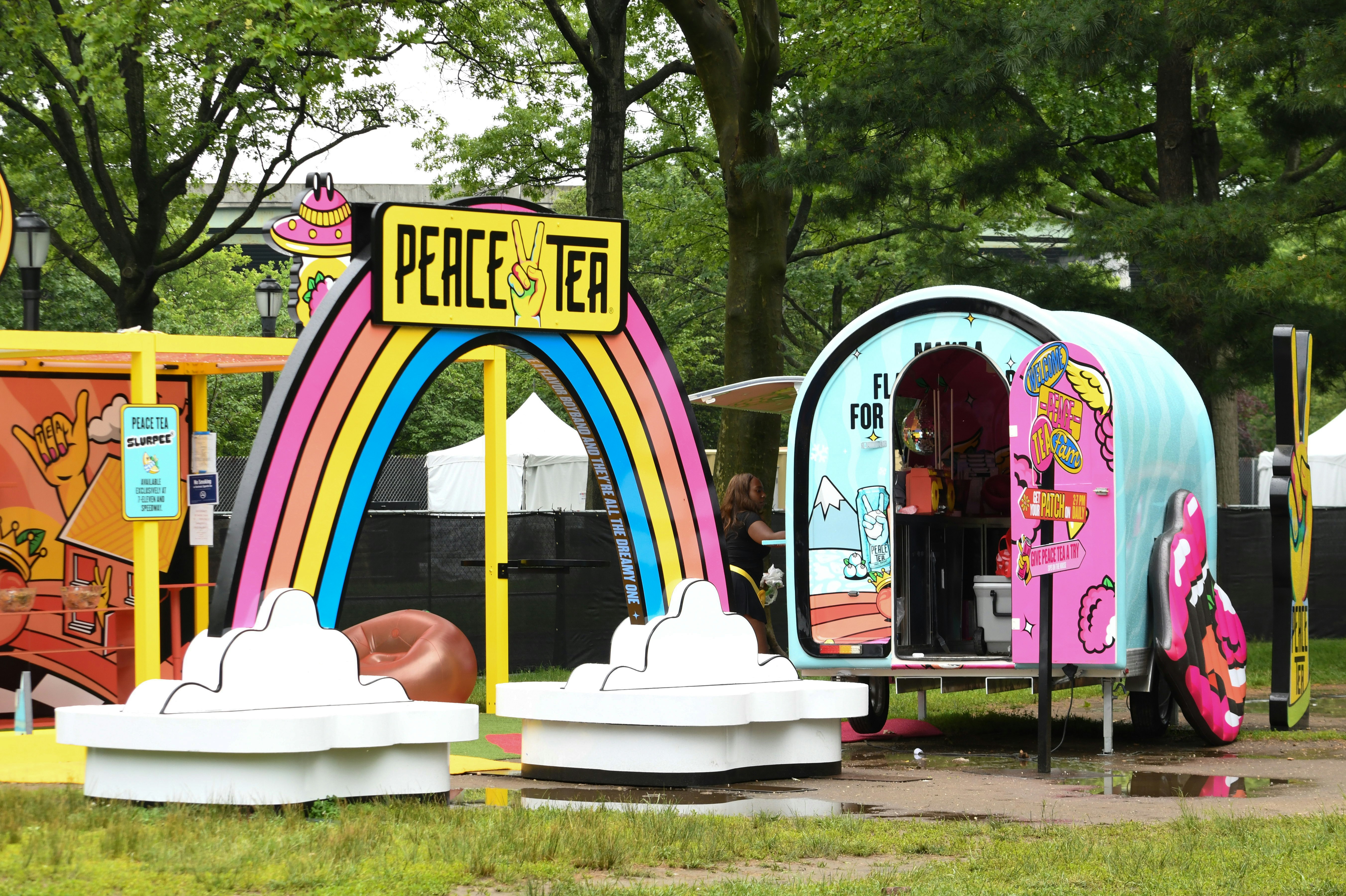 Peace tea stand and colorful cart set up outdoors.