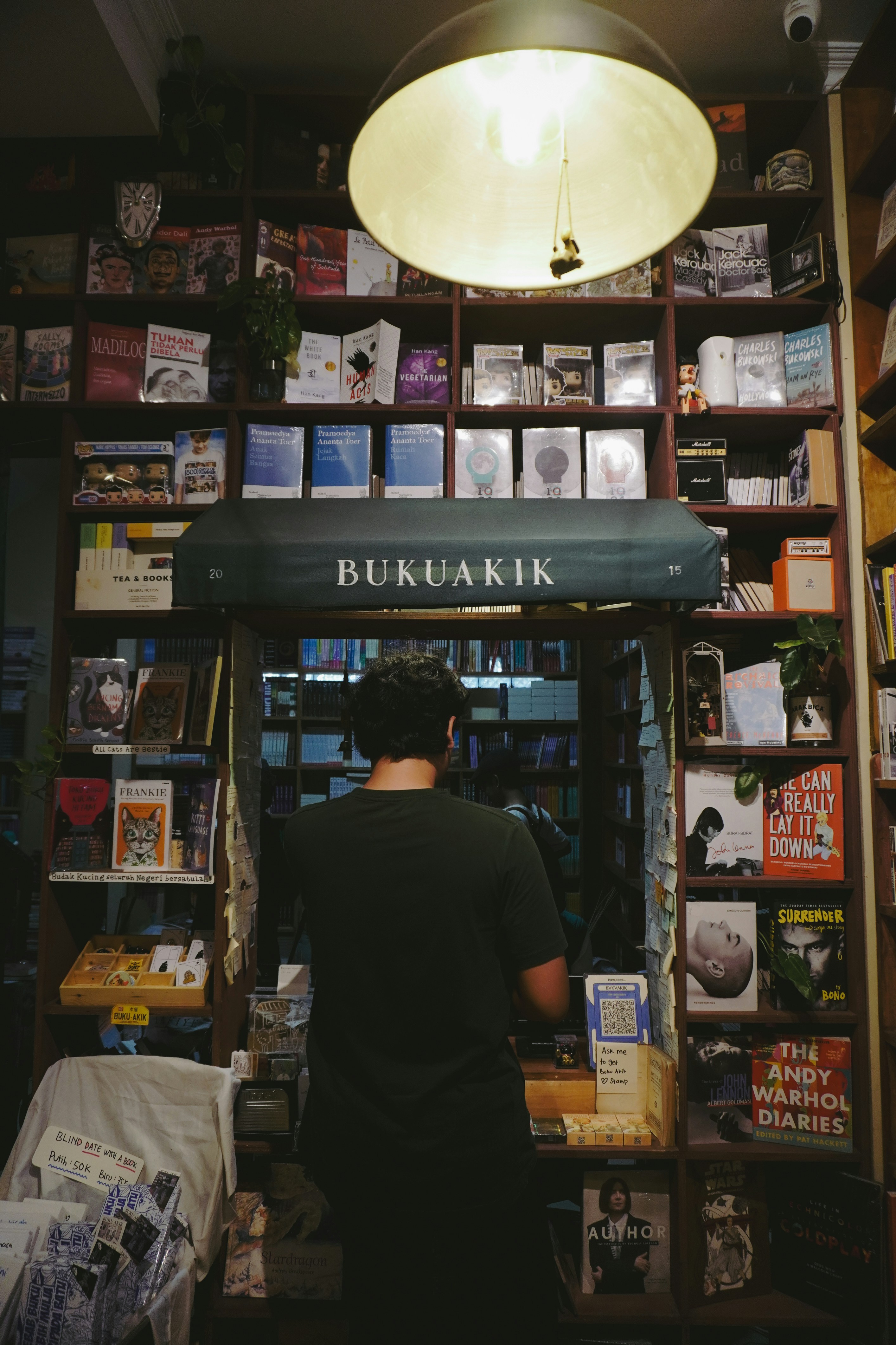 A person browses books in a cozy bookstore.