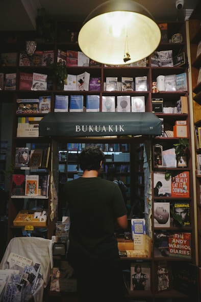 A person browses books in a cozy bookstore.