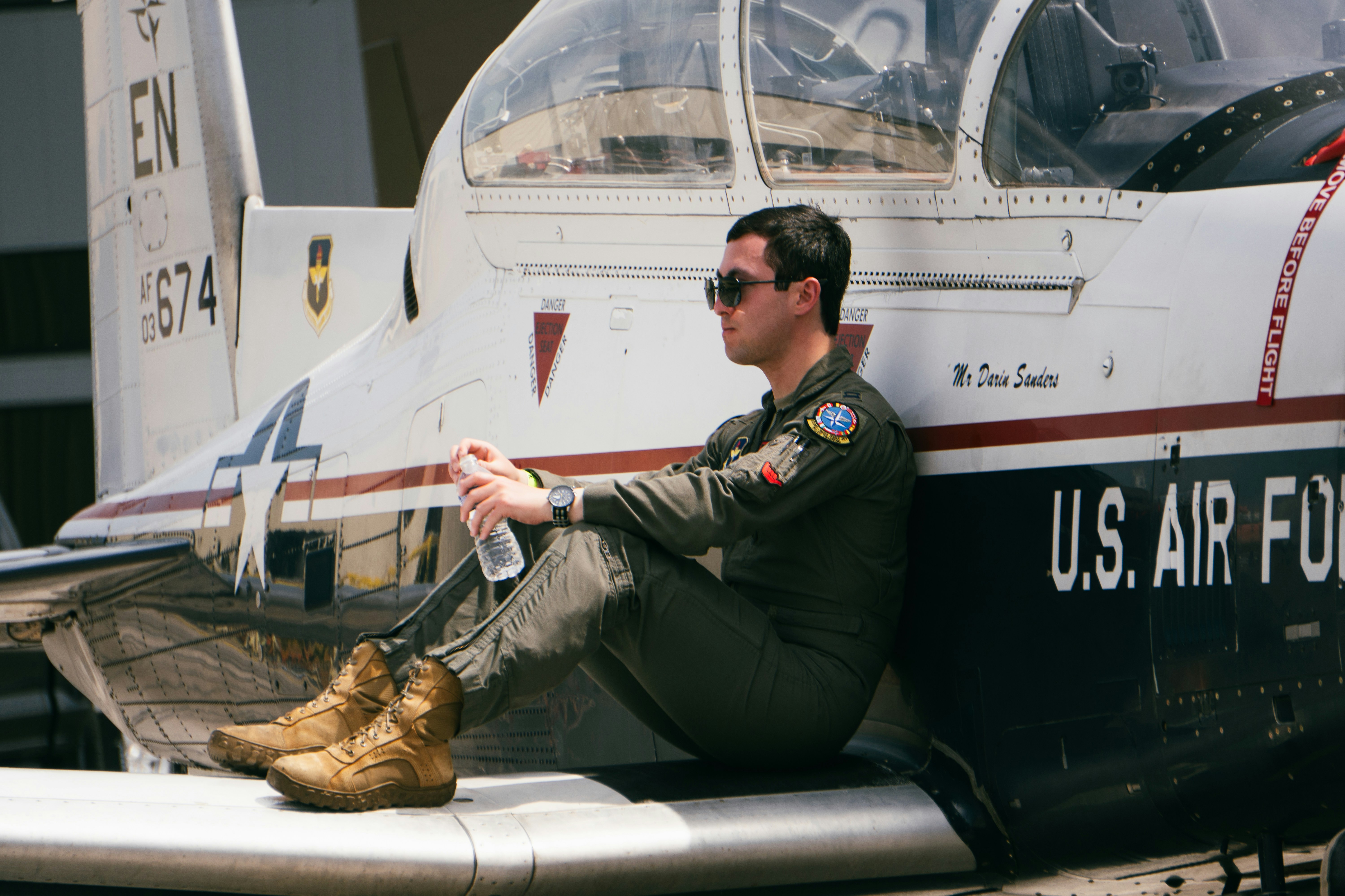 Il pilota dell'aeronautica si riposa sul suo aereo.