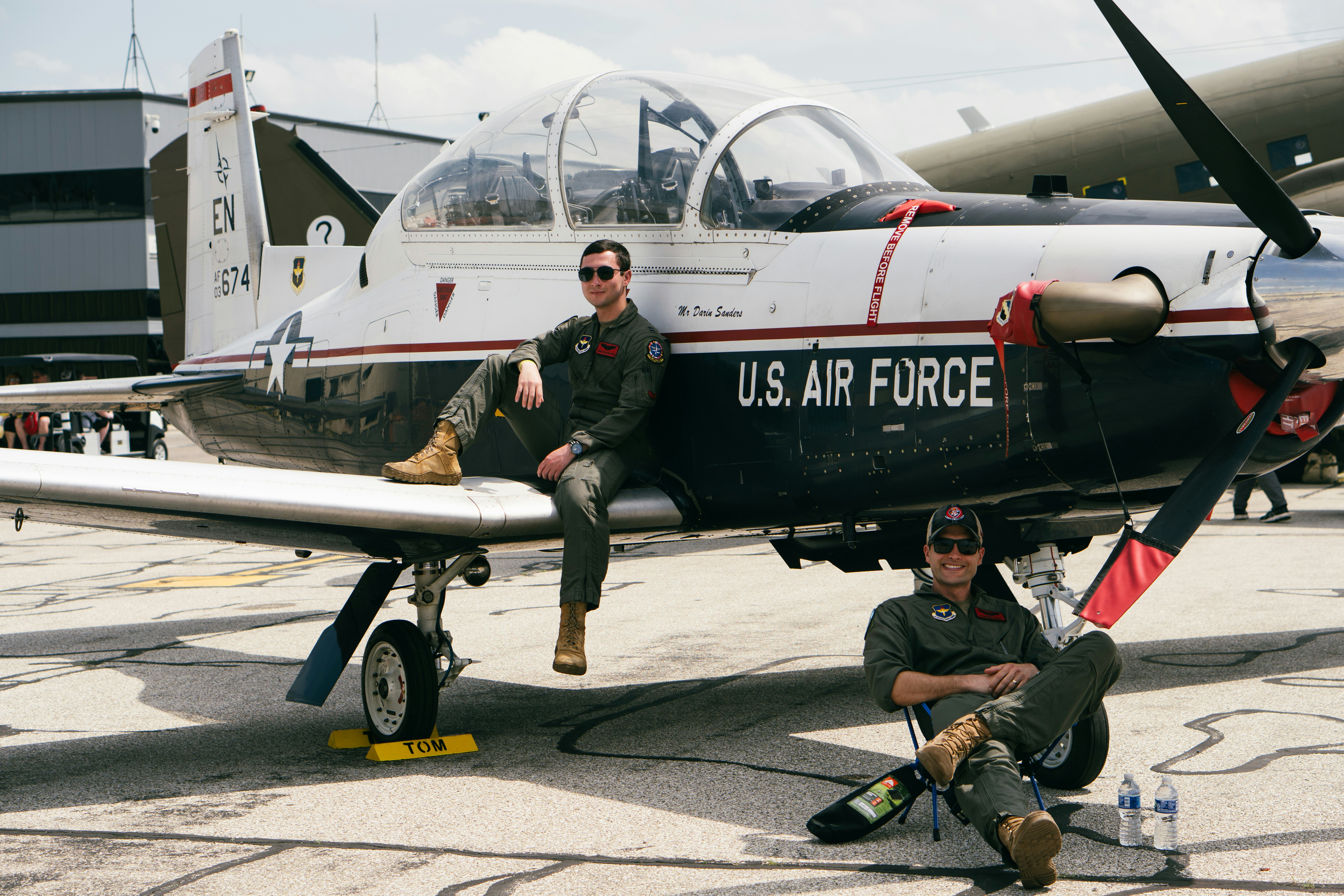 Due piloti dell'aeronautica si rilassano vicino al loro aereo.