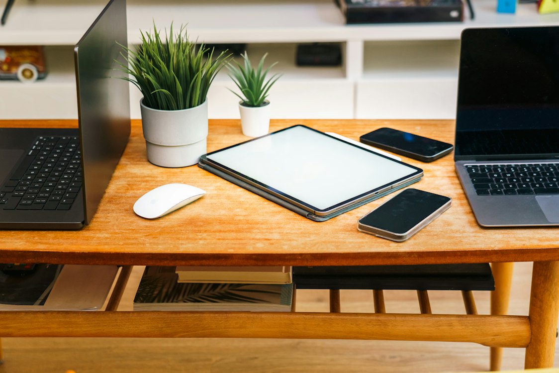 Multiple devices — laptop, tablet, and phone — on a desk representing multi-device streaming