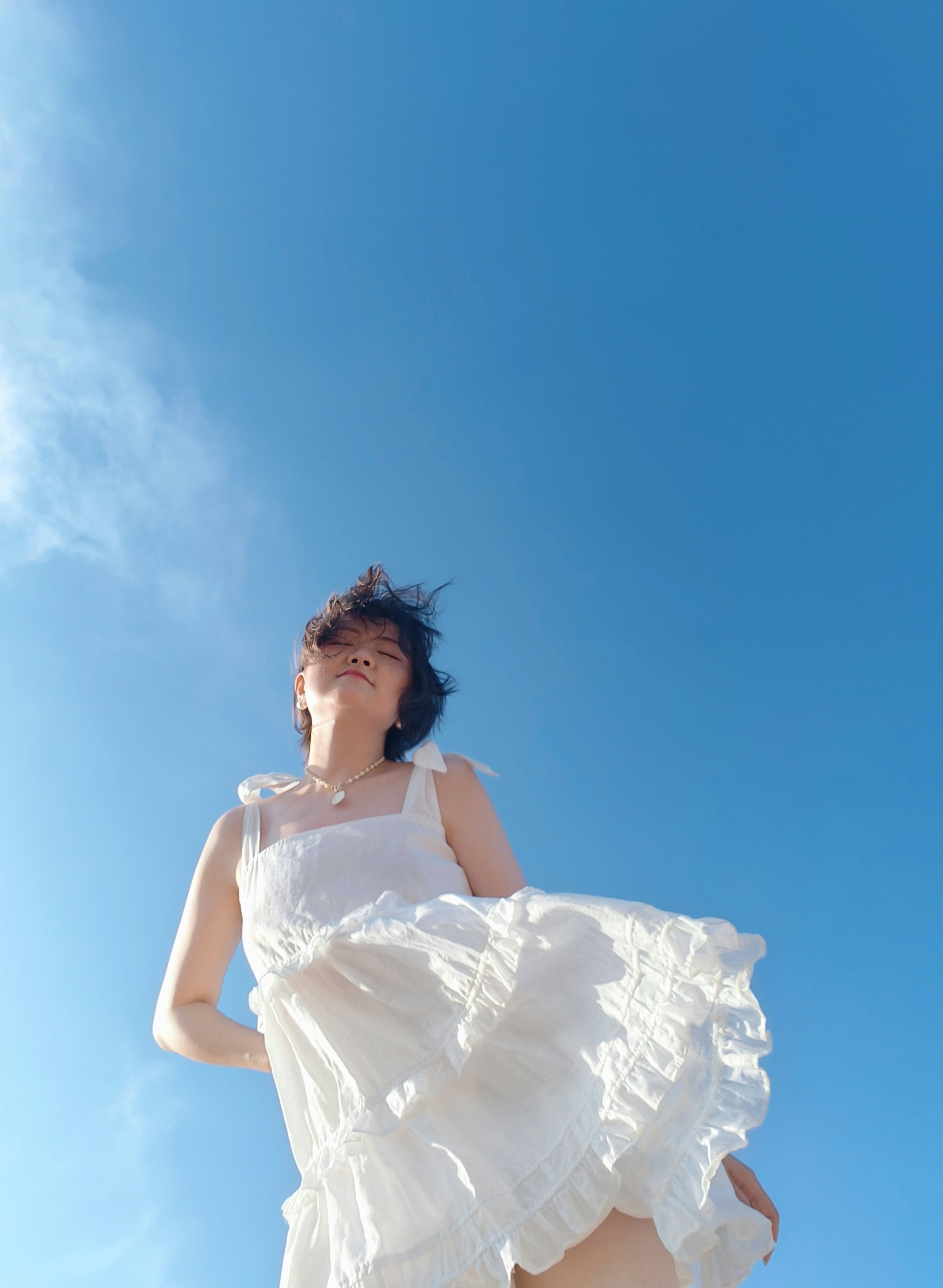 Woman enjoys bright sunshine and blue sky.