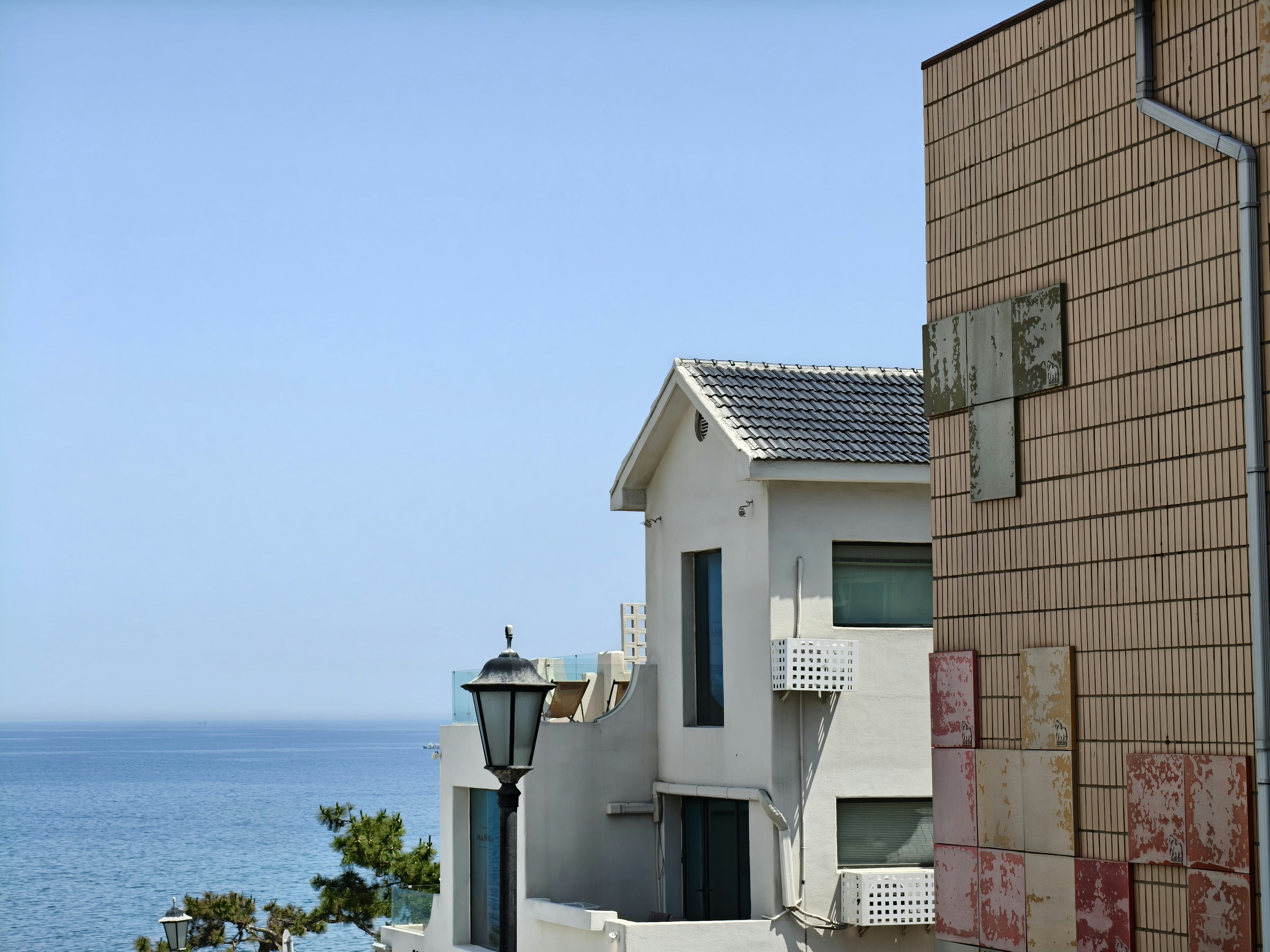 Houses overlook the ocean on a sunny day.