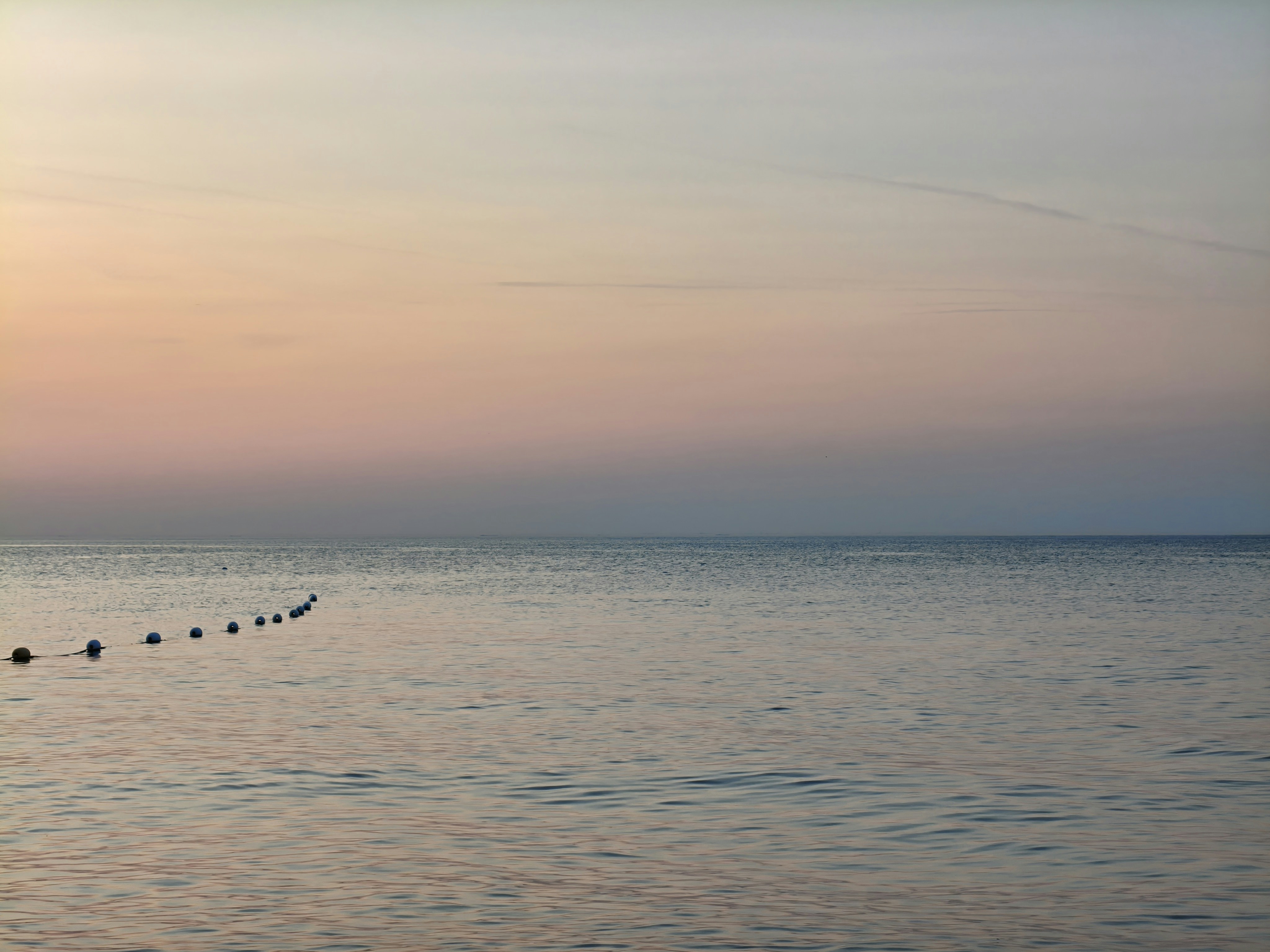 Serene ocean scene with colorful sky.