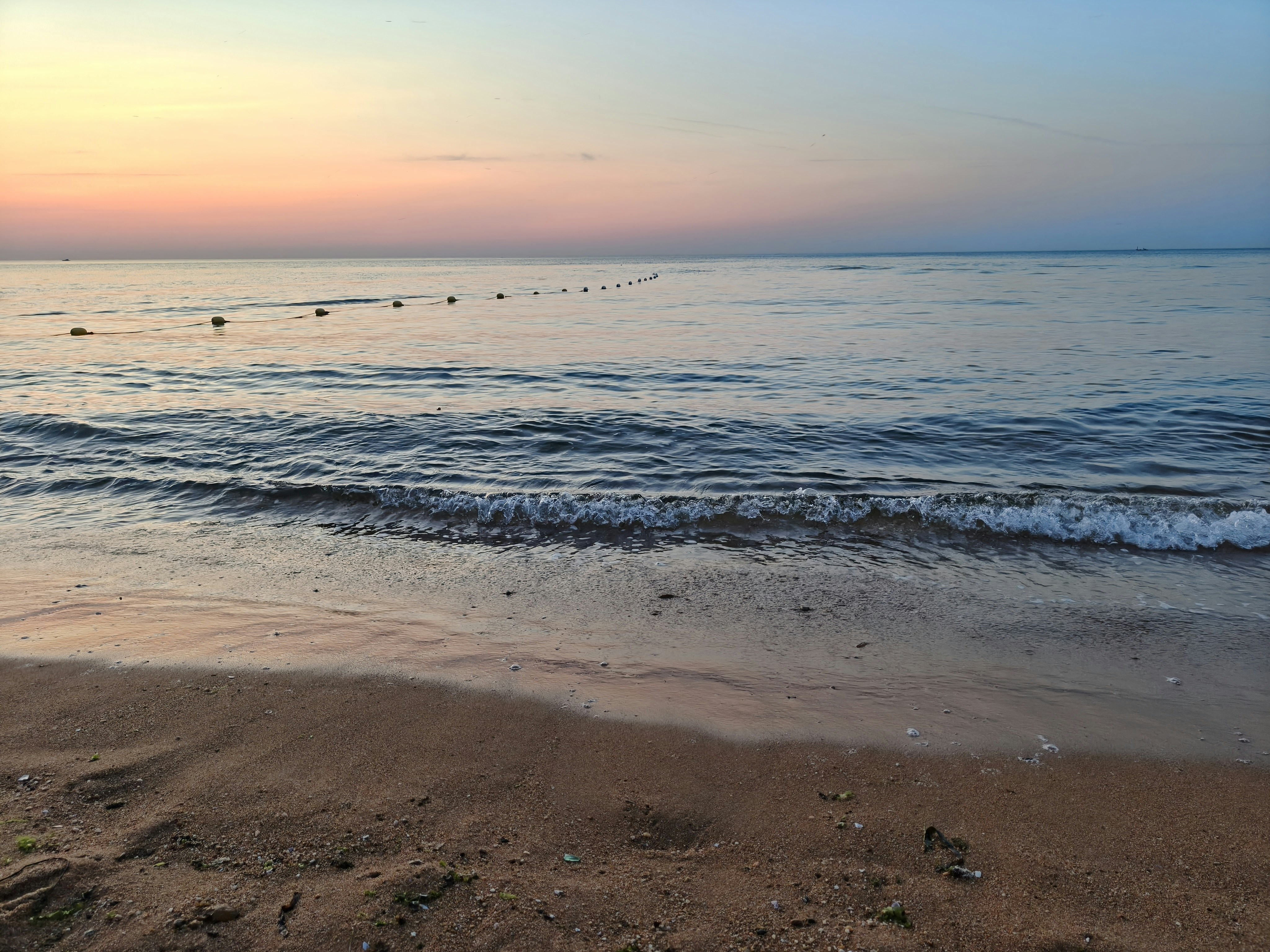 Sunset over the ocean, with a calm, serene view.