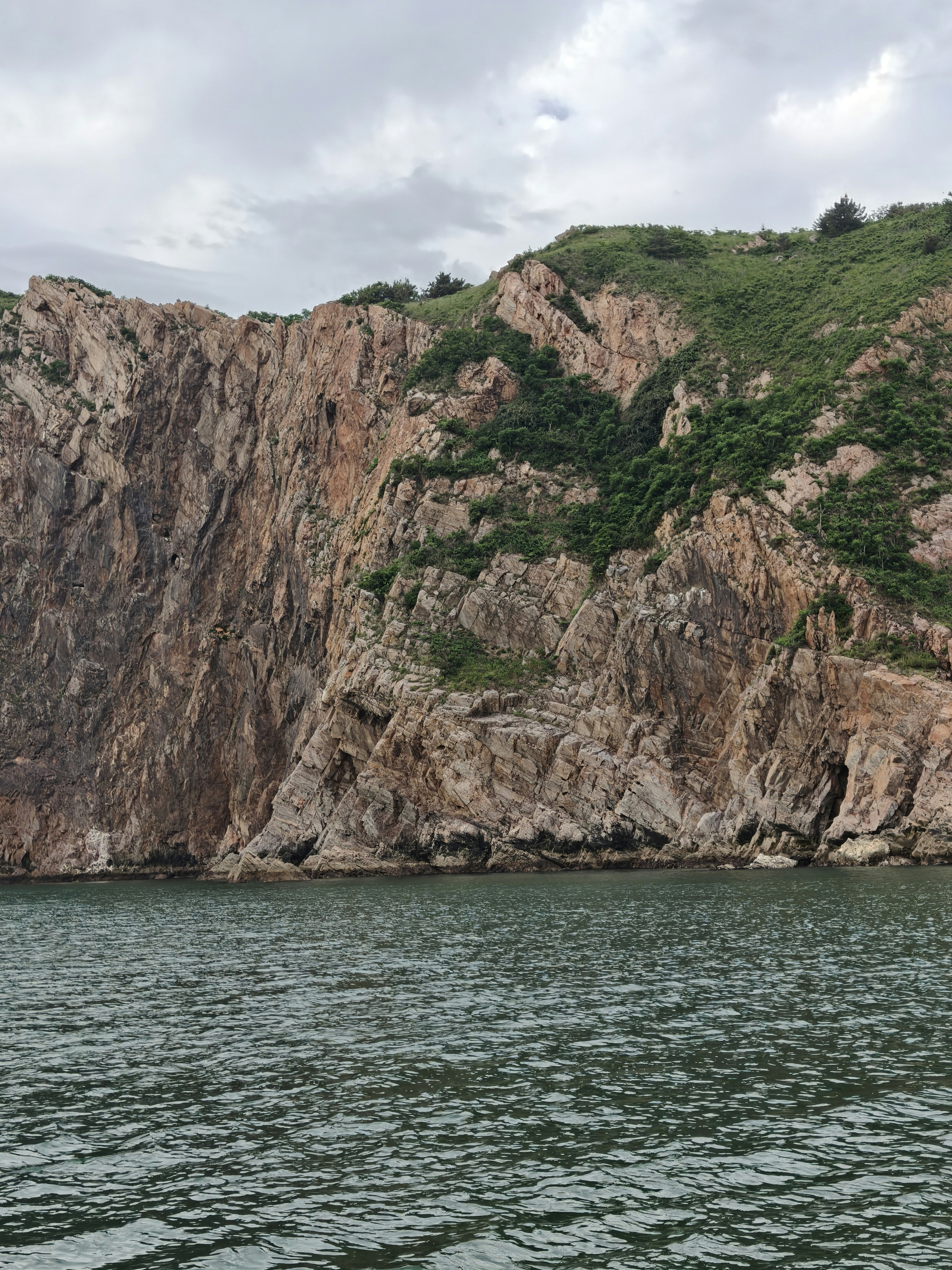 Cliffs rise above a calm body of water.