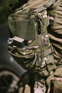 A military-style backpack with camouflage pattern.