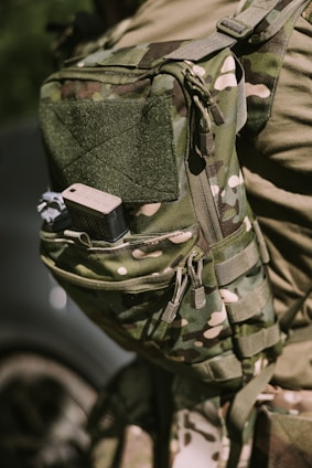A military-style backpack with camouflage pattern.