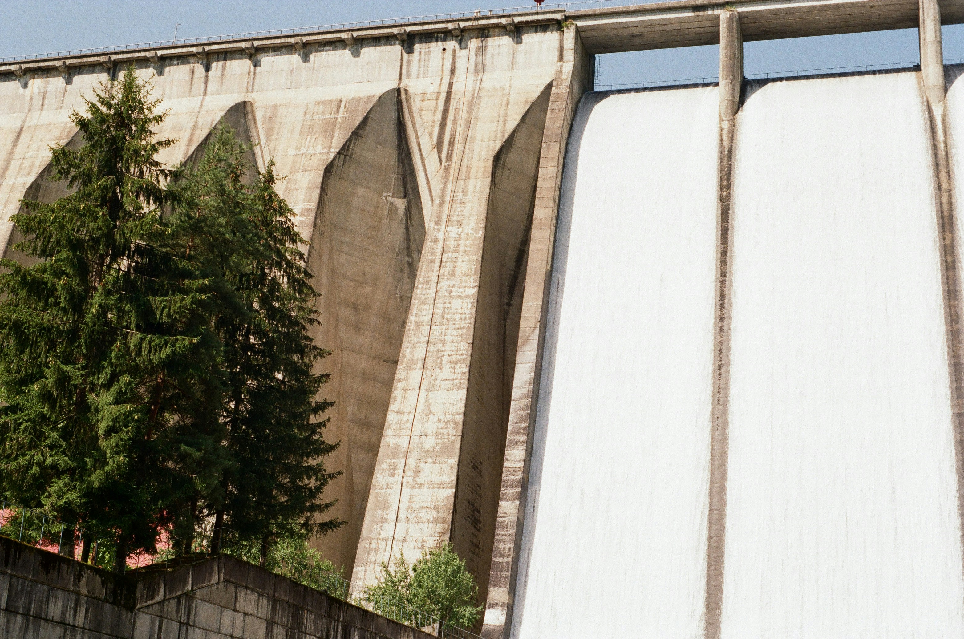 Water cascades powerfully over the concrete dam.