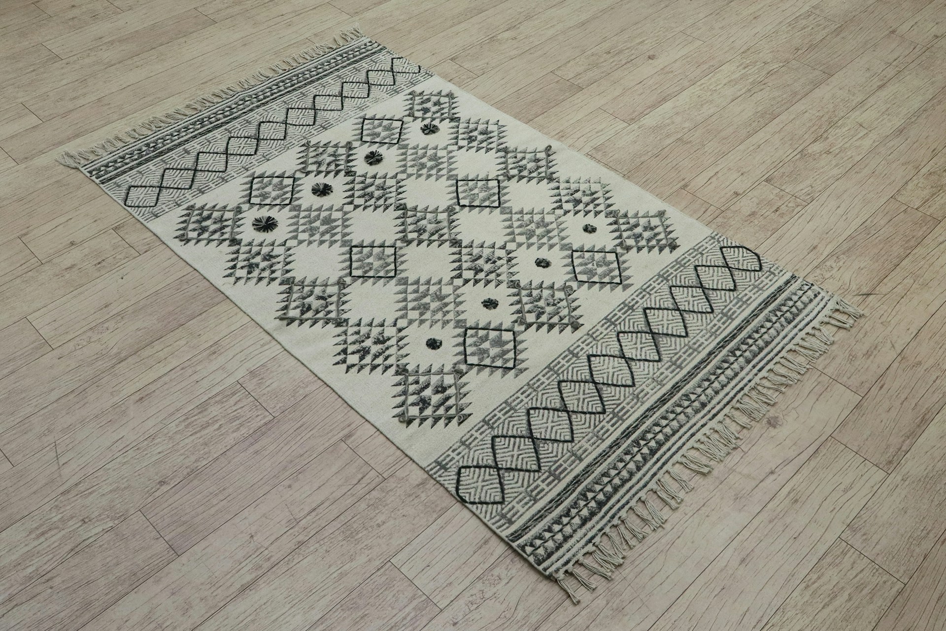 A patterned rug sits on a wooden floor.