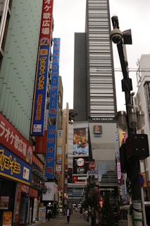 A narrow city street in japan, with many buildings.