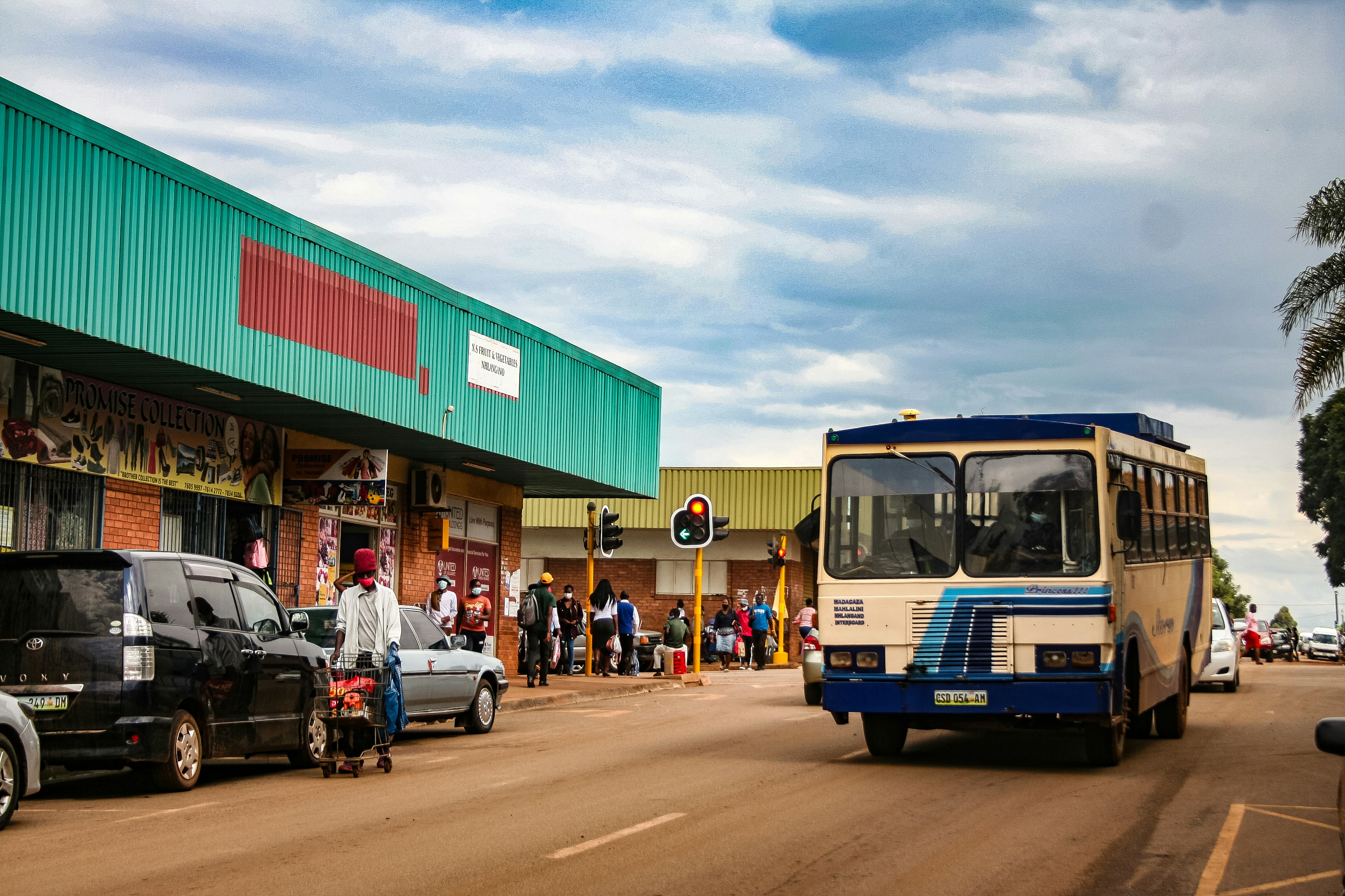 A bus drives down a street with shops.