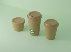 Three recyclable cups sit on a light green surface.