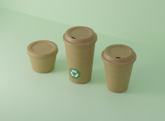 Three recyclable cups sit on a light green surface.