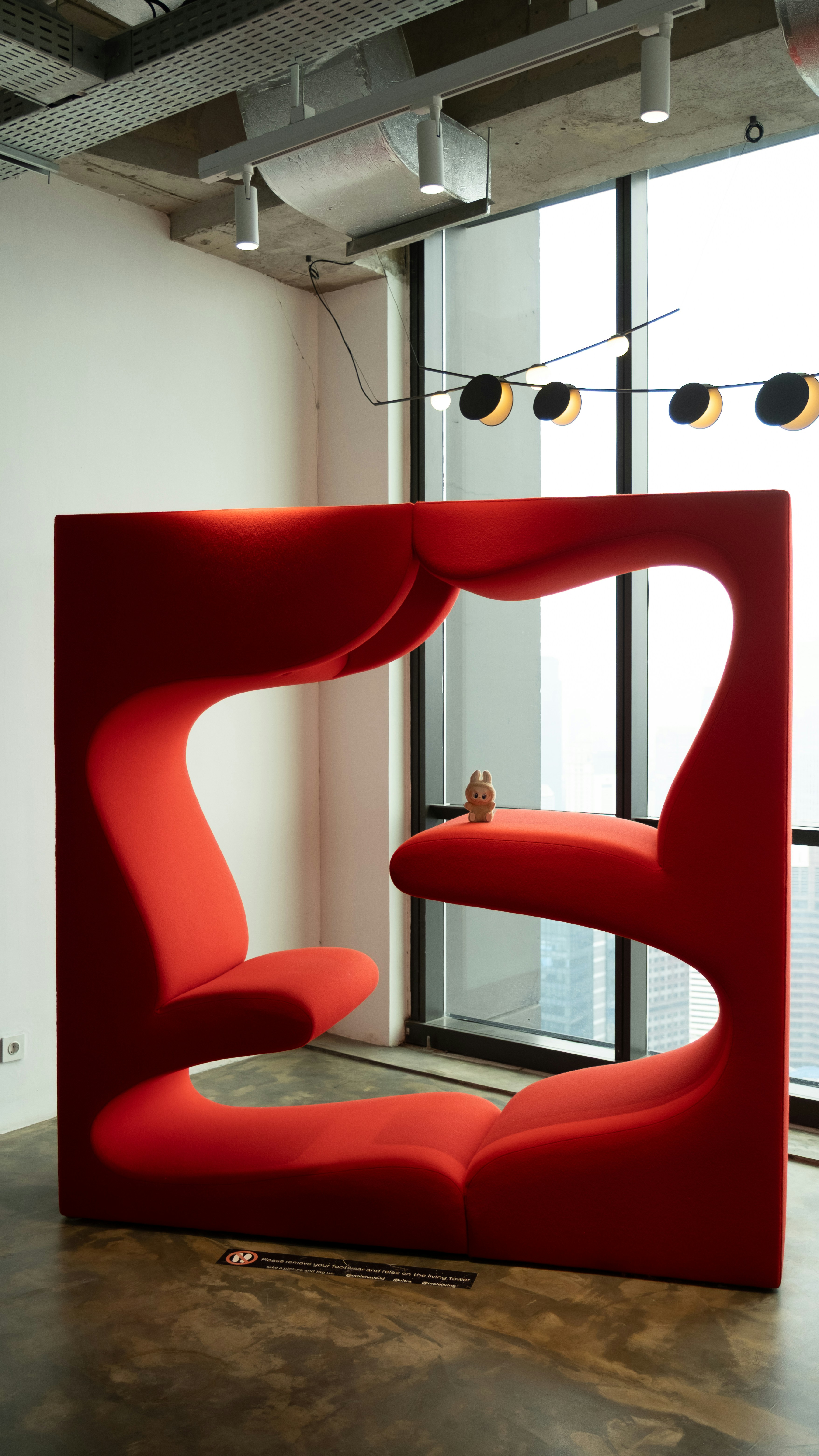 A modern red lounge area with city view.