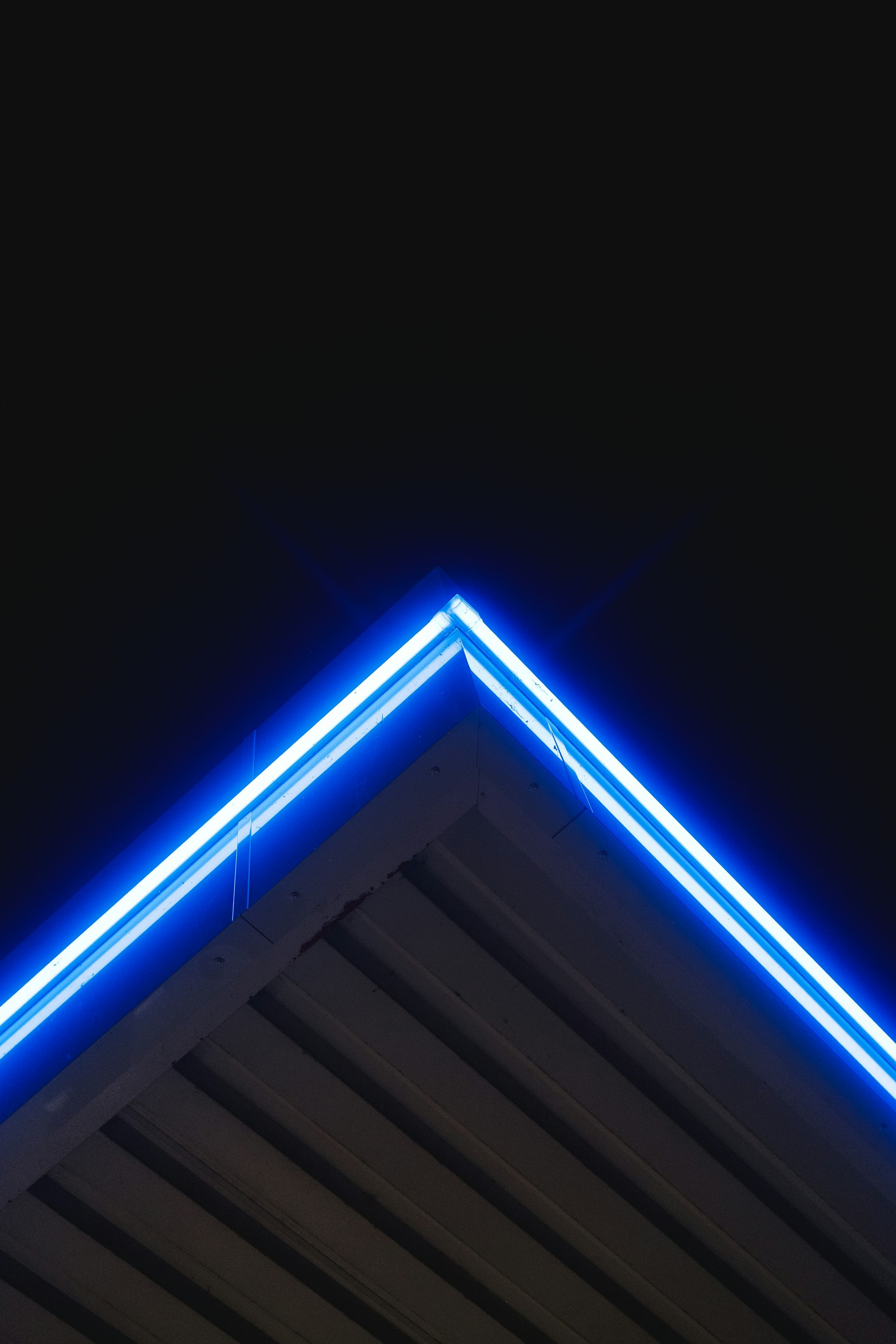 Blue neon lights illuminate an angled roof.
