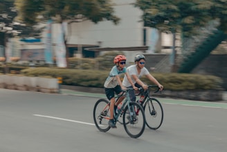 Two cyclists are riding bikes on a road.