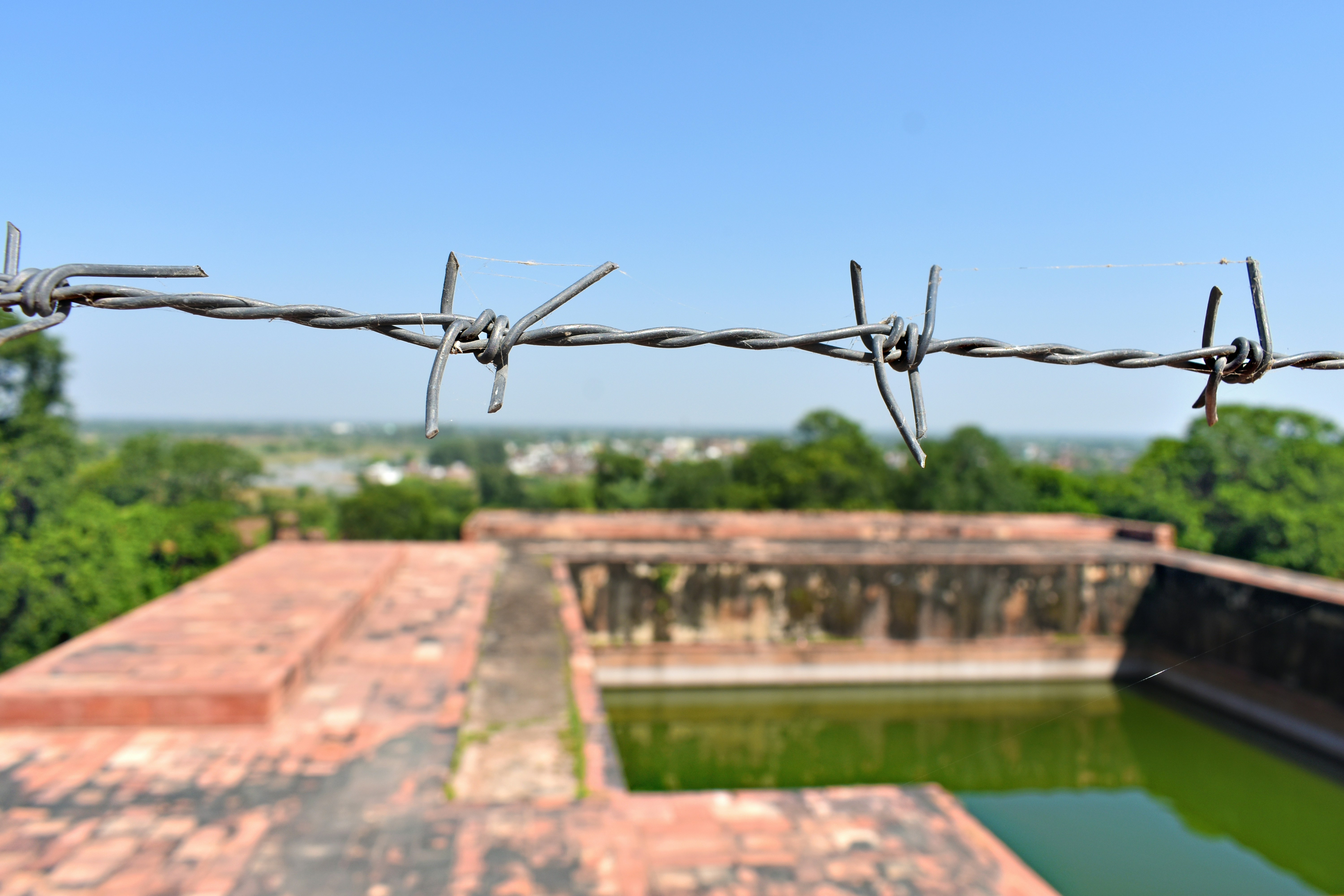 Barbed wire is in front of an outdoor scene.