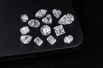 Diamonds of various shapes are on a black surface.