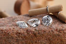 Sparkling diamonds rest on a rough stone.