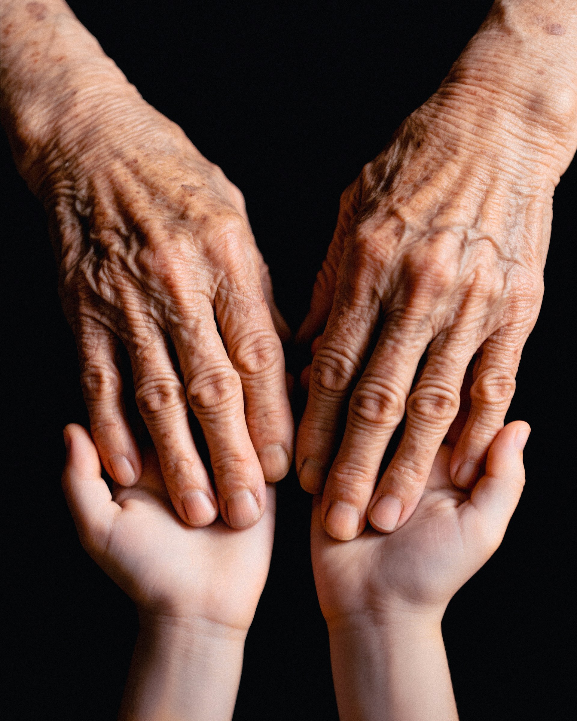 Old hands cradling the younger ones.