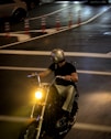 A motorcyclist rides at night.
