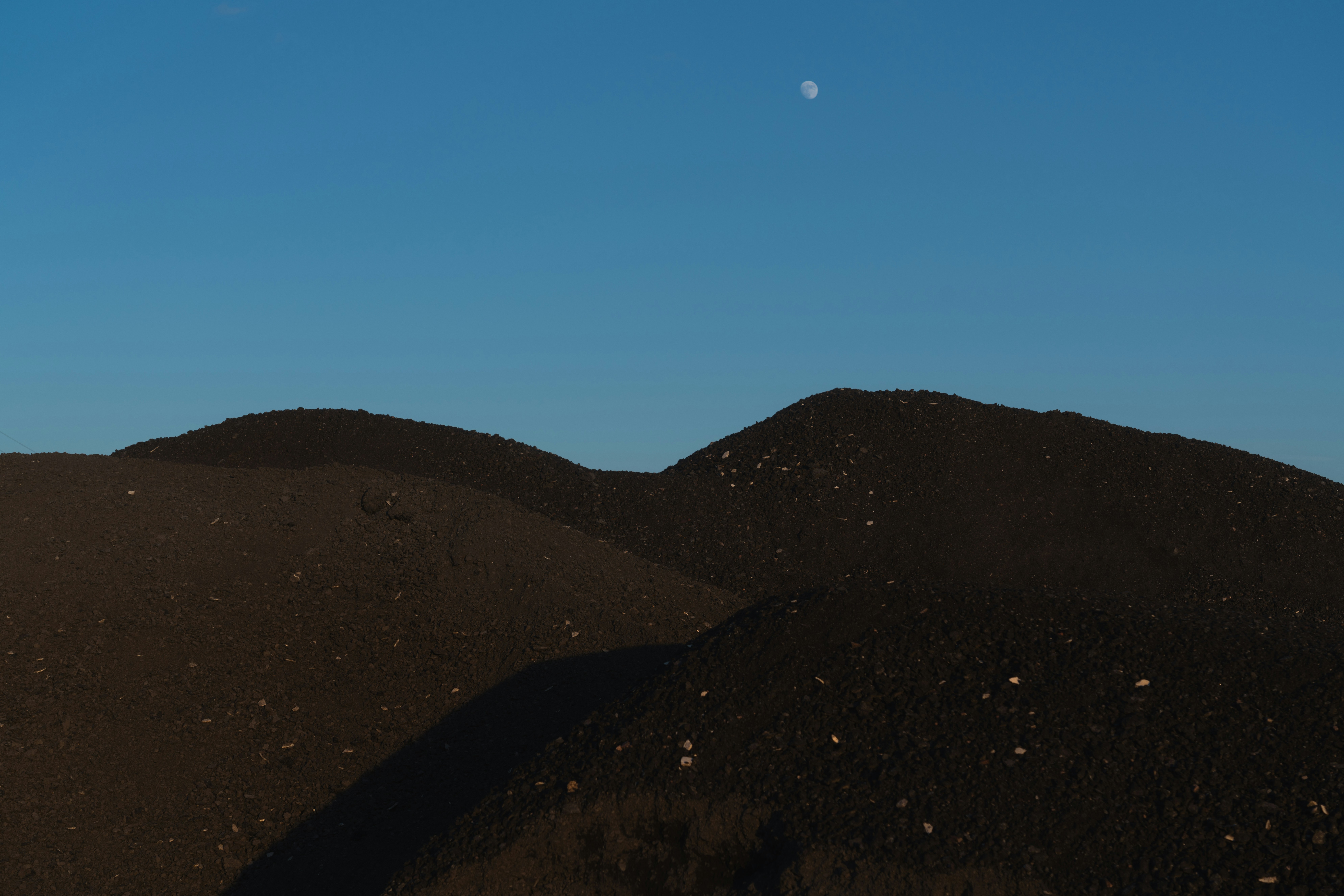 Des montagnes et une lune sont visibles dans le ciel.