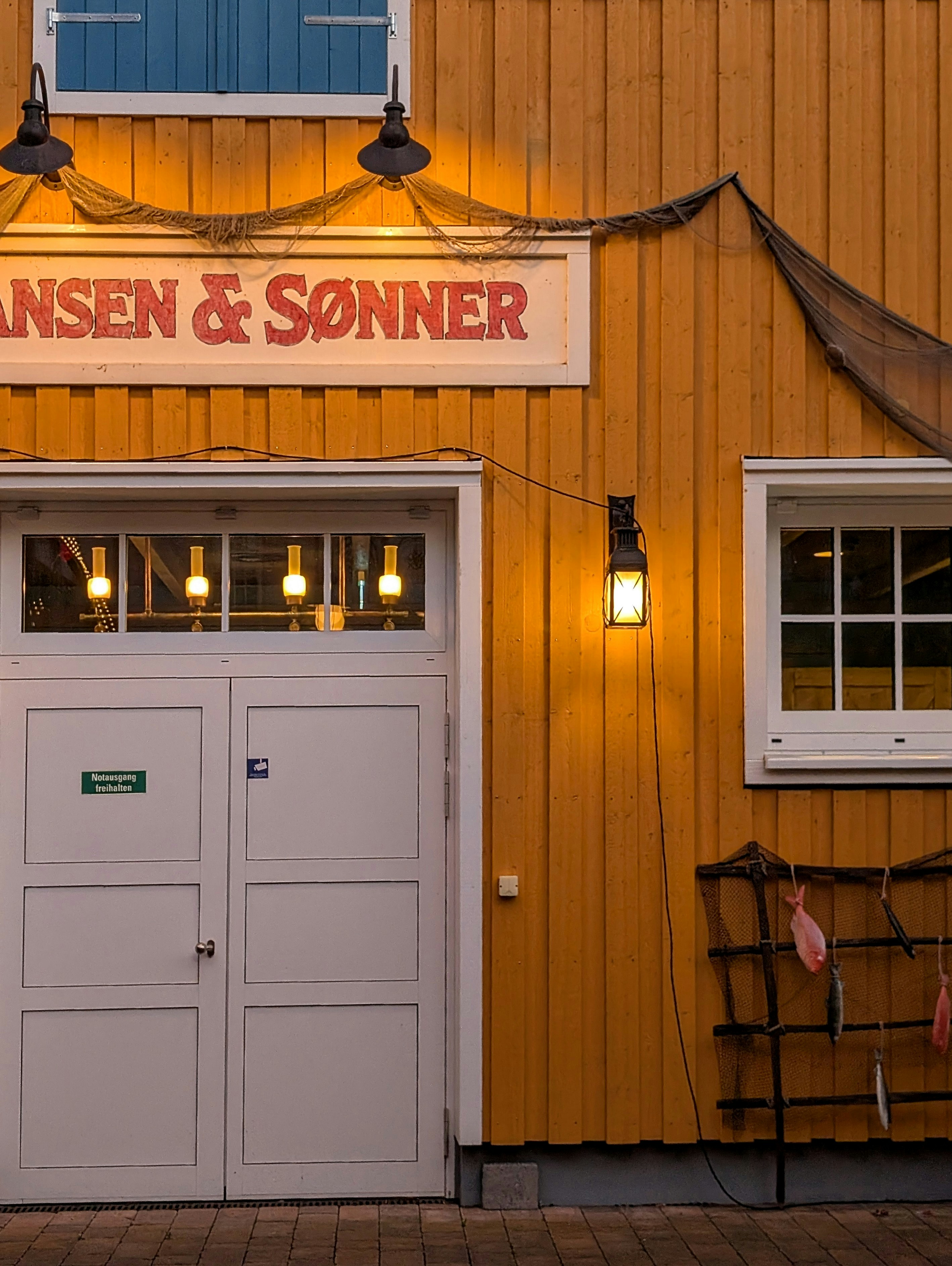 Edifício amarelo com sinal e porta da garagem.