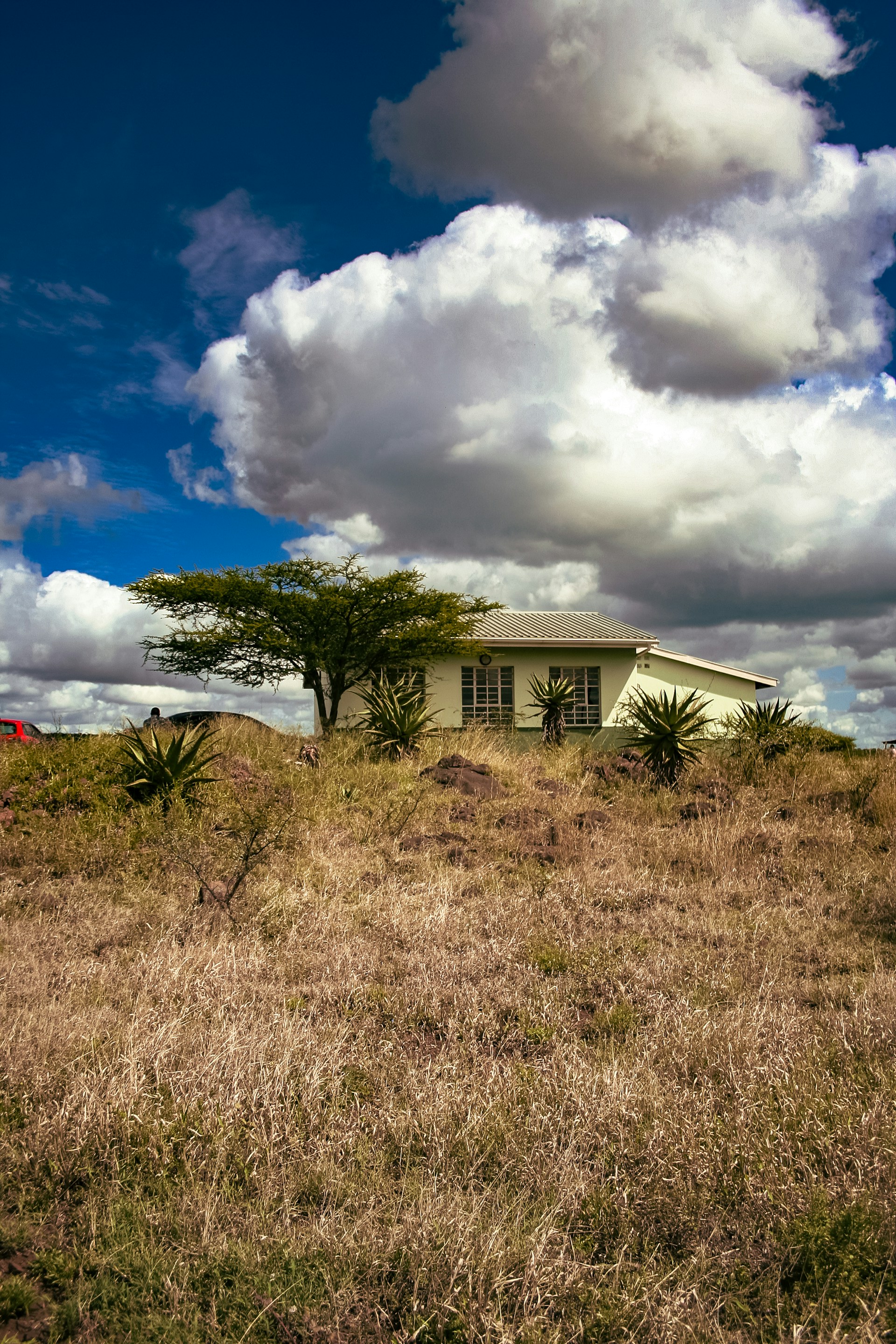 A small house stands beneath a cloudy sky.