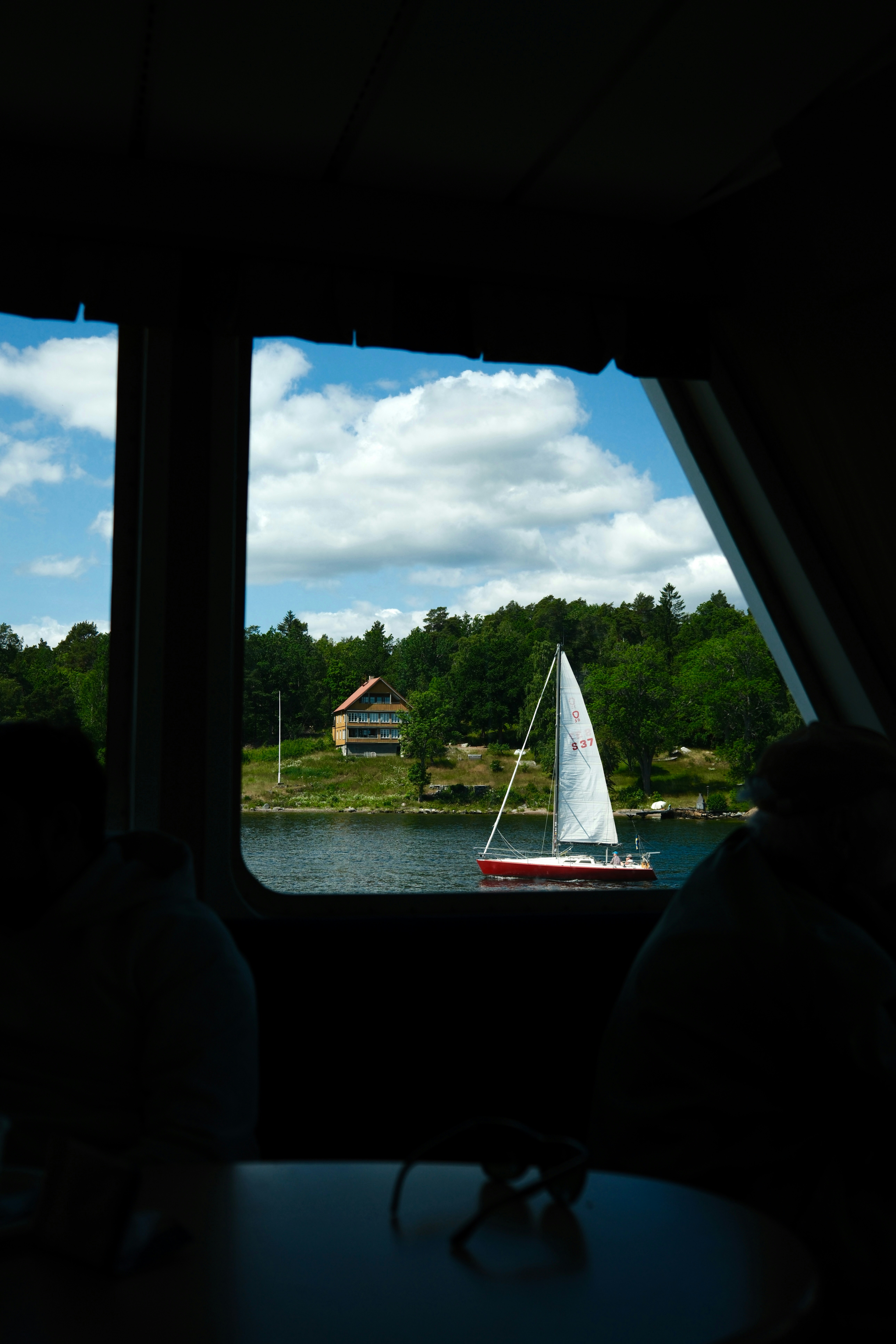 A sailboat sails through the bright daylight.