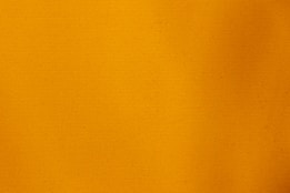 A plain orange background fills the image.