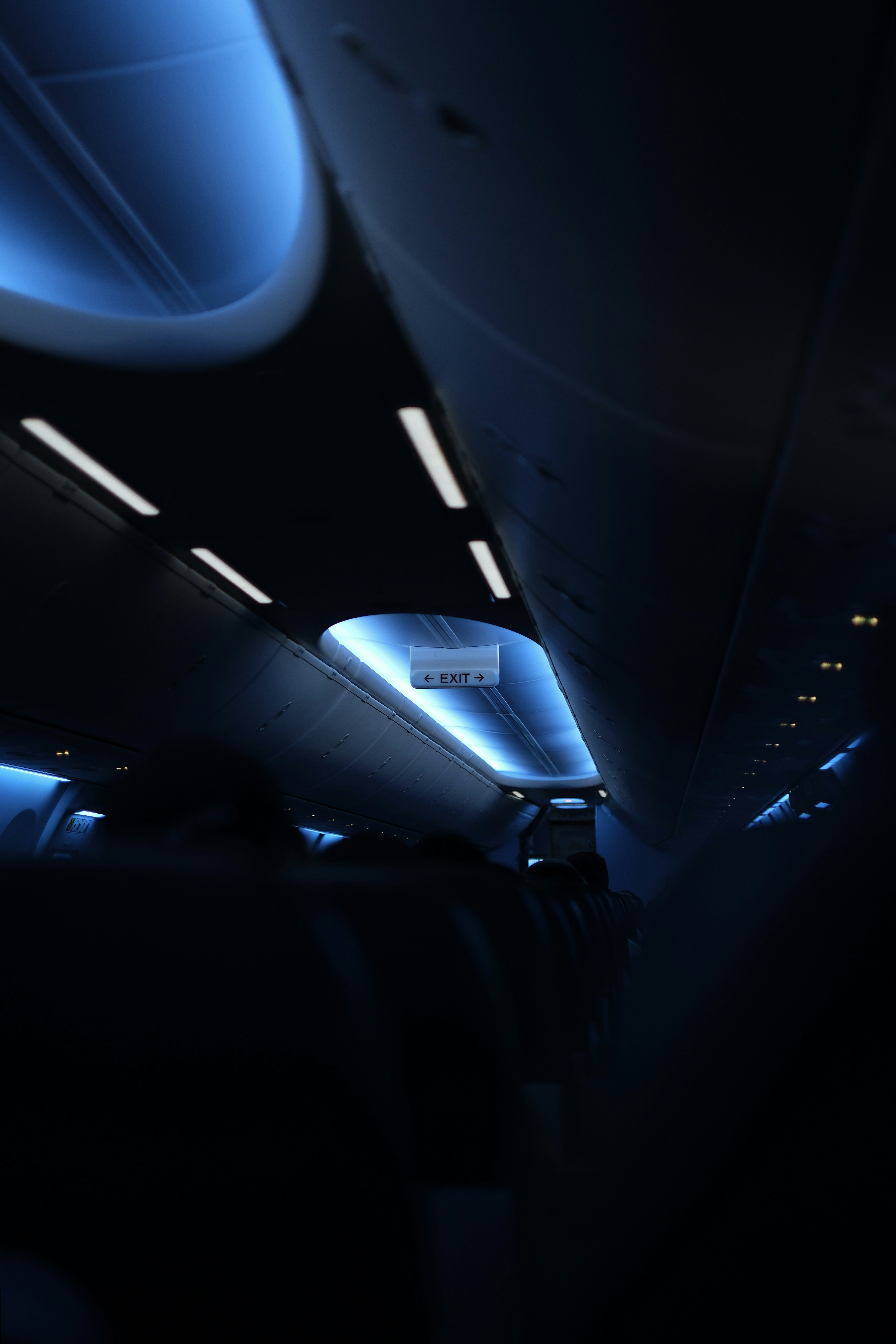 Interior of an airplane cabin with blue lighting.